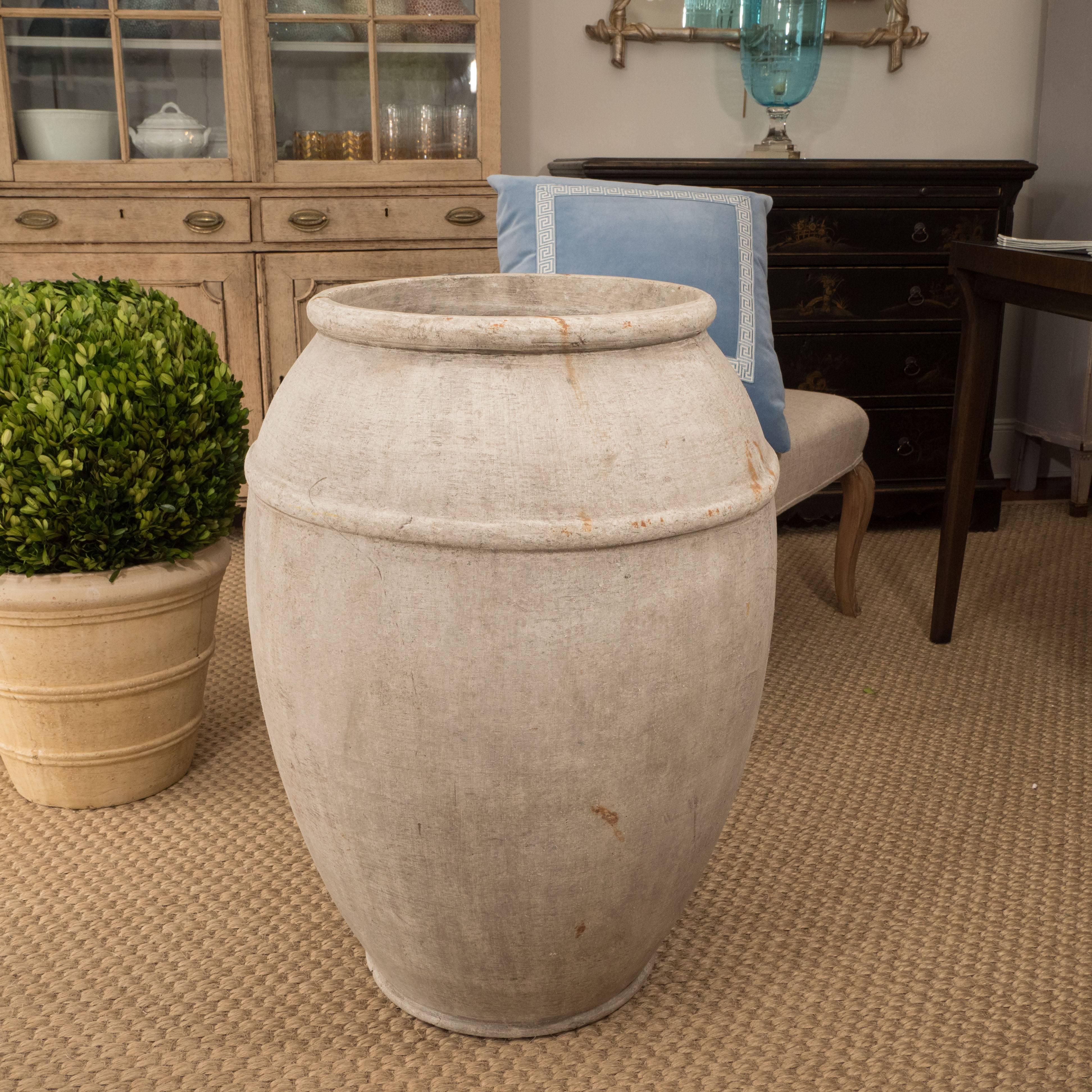 Its graceful shape gives this large cement urn a quiet elegance. Inside or out, this piece would look great with plantings or without.