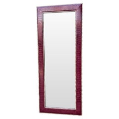 A large full length mirror with burgundy faux crocodile skin frame.