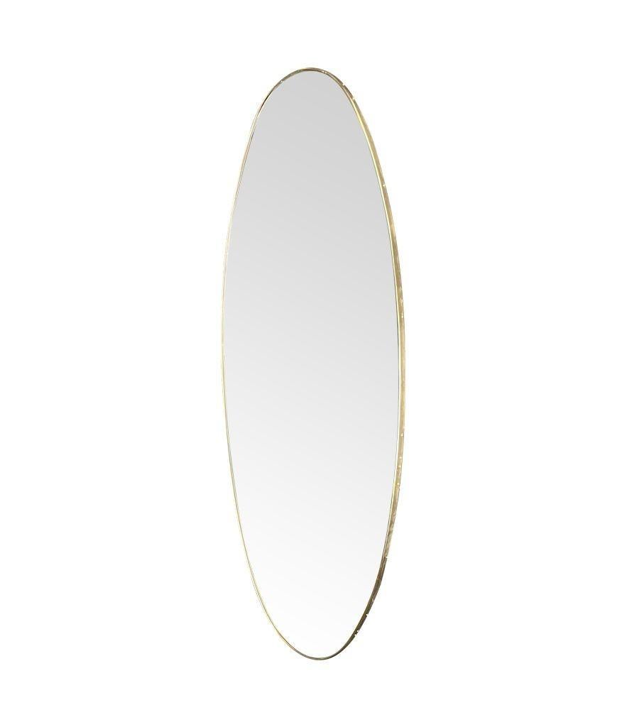 Grand miroir ovale original des années 1950, encadré de laiton, avec dos en bois. Les fixations permettent de l'accrocher à l'horizontale ou à la verticale.