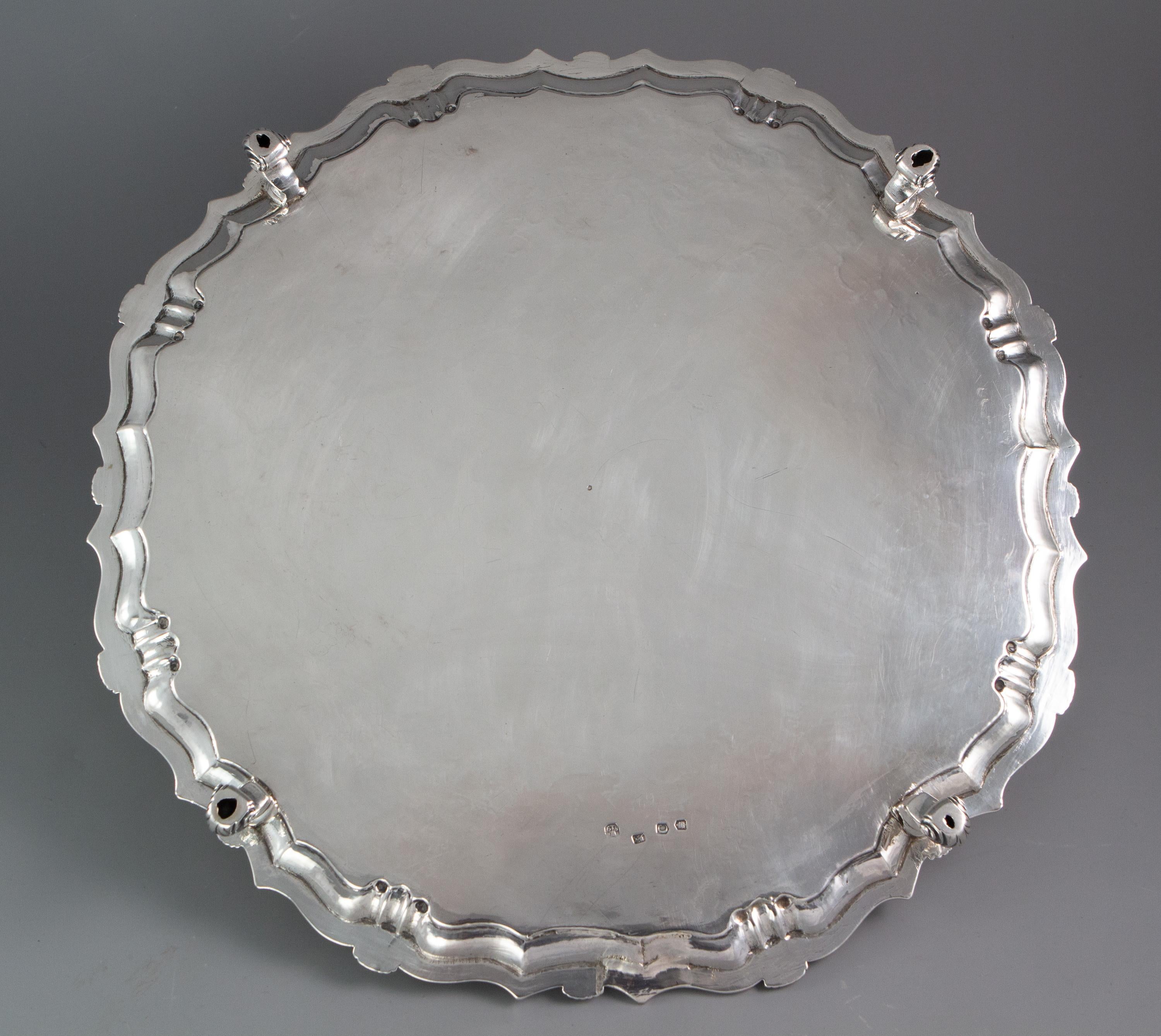 A large and impressive George II octagonal silver salver with pie crust edge and shell decoration. The central plate engraved with cornucopia of fruits and flowers amidst patterned arabesques. The centre engraved with an armorial beneath a crown.