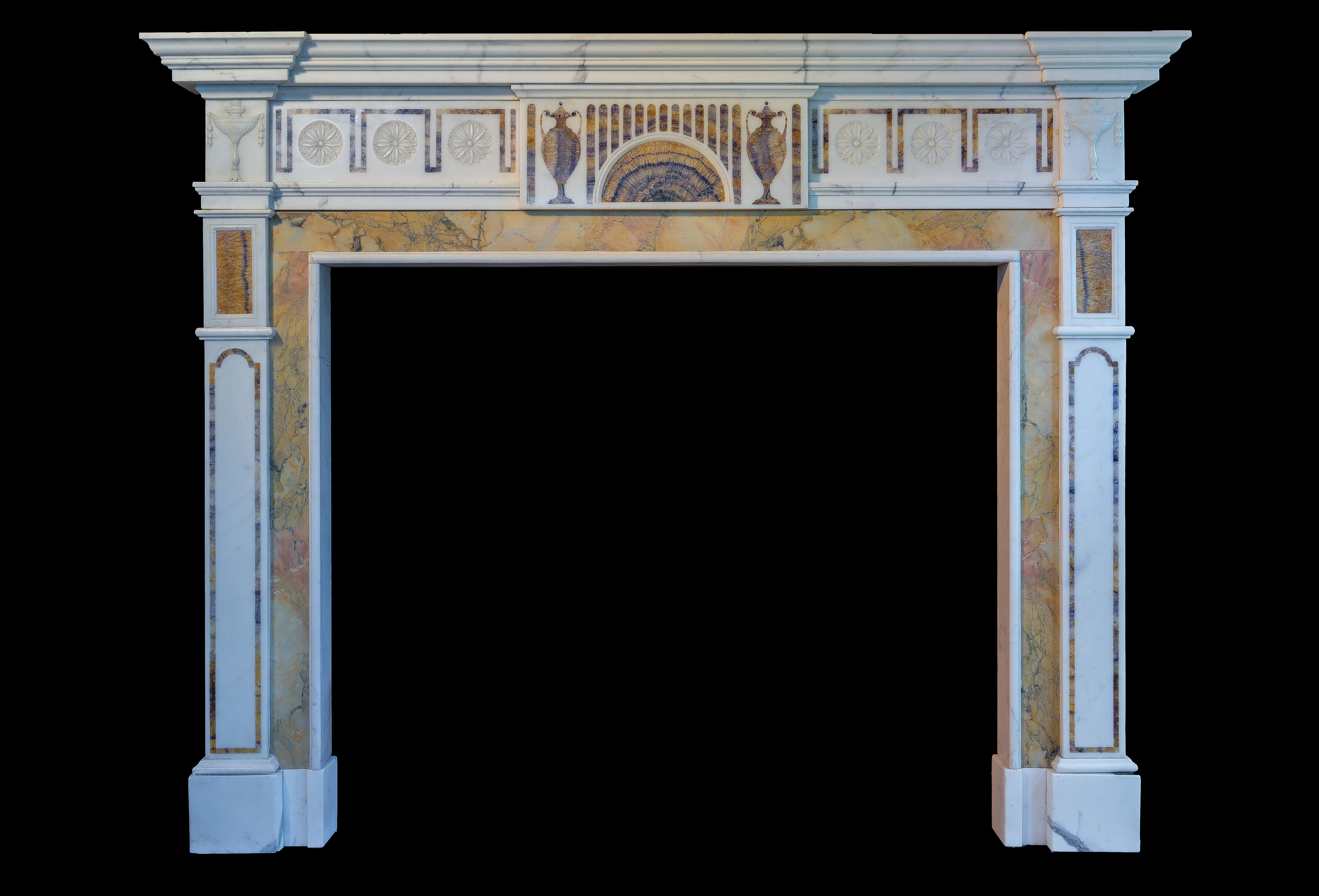 A large and very good quality Georgian style fireplace surround. In Statuary white marble with rare BlueJohn marble tablet and inlay. The jambs with Bluejohn inlay and Siena marble ingrounds, surmounted by classical carved urn corner blocks. 
The