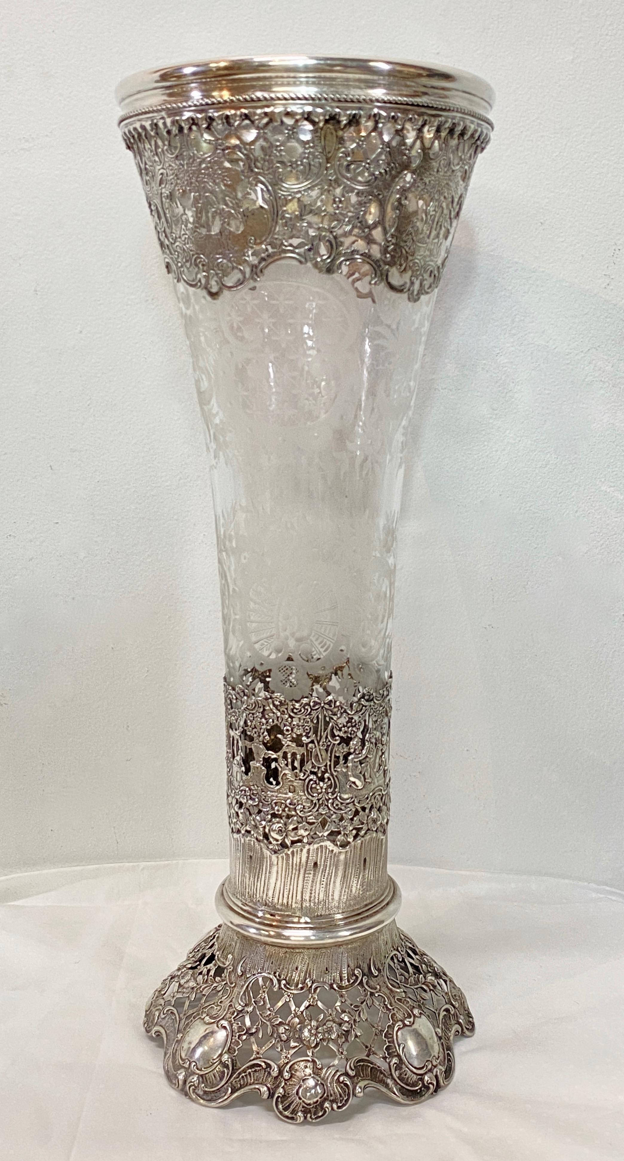 Eine große deutsche Hanau 800 Silber montiert repousee und durchbrochene Arbeit - geschliffen und geätzt Glas Trompete Vase.  Geformte Umrandung mit Wulstrand,  Blumen- und Puttenmotiv mit Kartuschen.  Das Glas mit aufwändigem Radschliffmuster. 