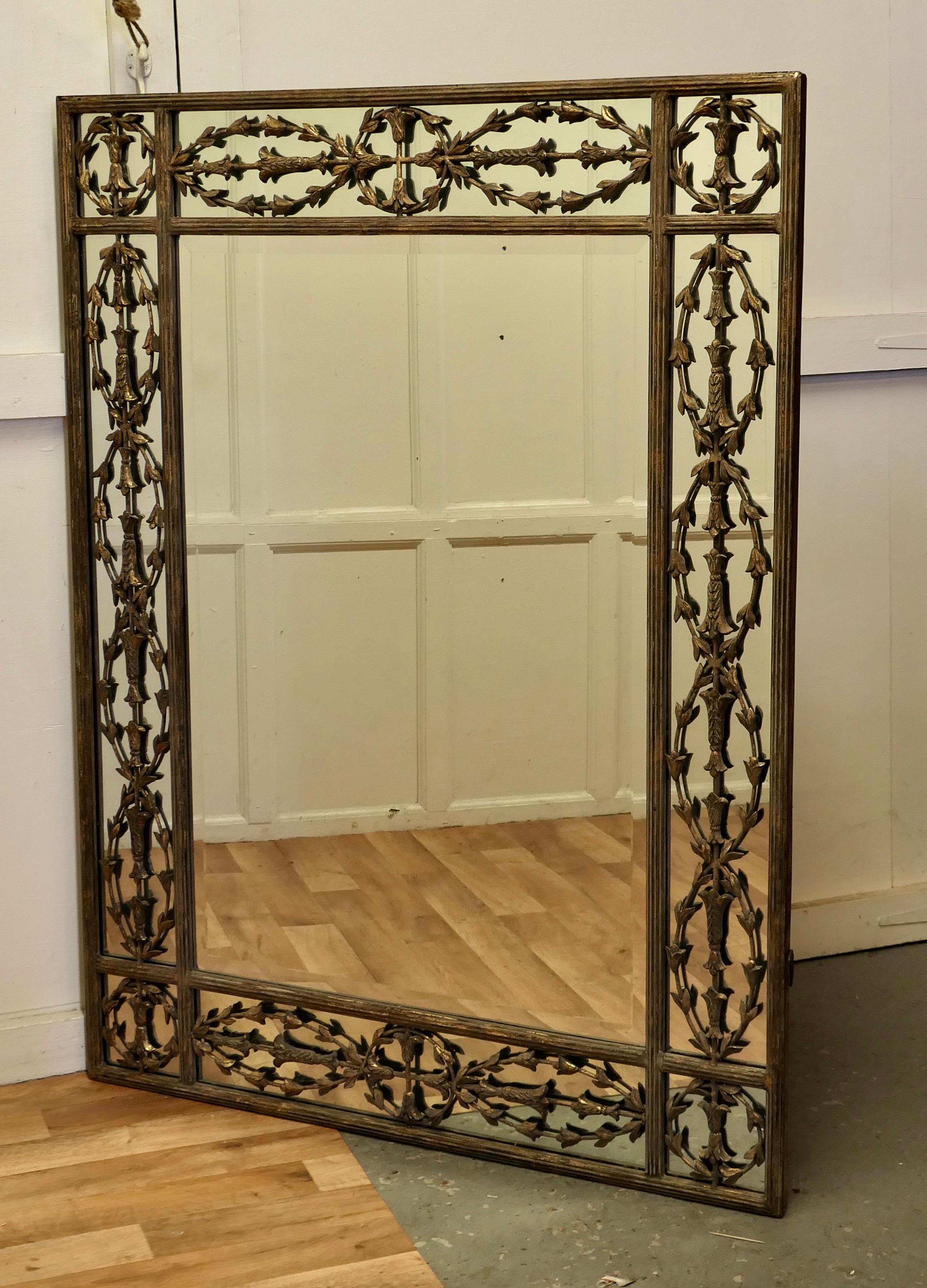 A large gilded iron margin wall mirror.

This is a large, heavy and very attractive stand alone, the central bevelled mirror has a beautifully Decorated 8” Frame, the mirror is bordered on 4 sides with intricate iron leaf-work over an additional