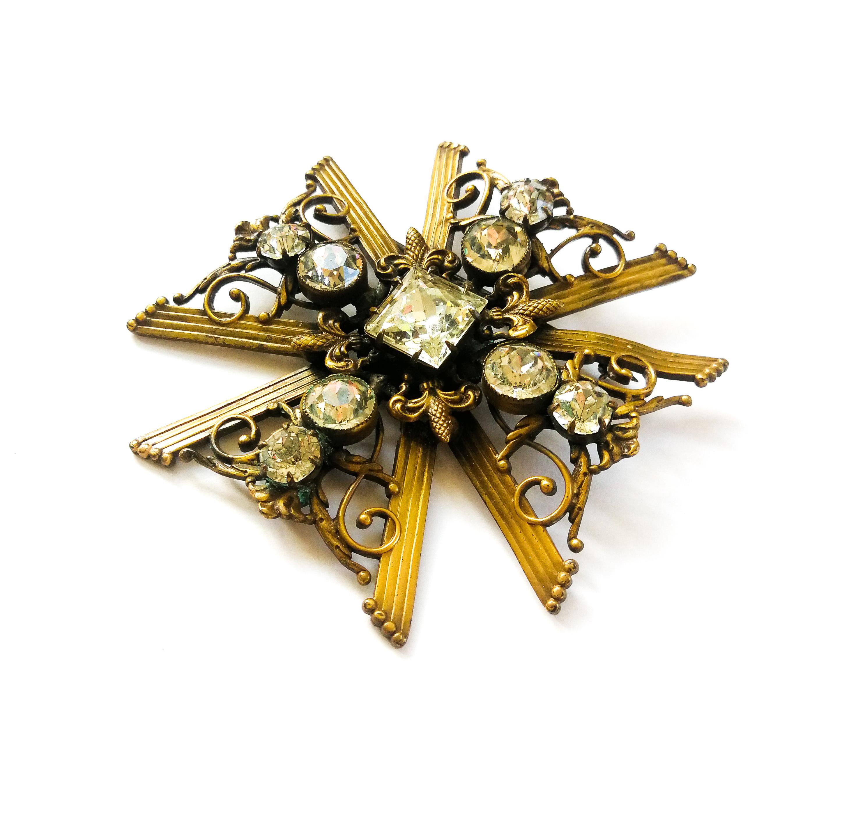 A charming and stylish brooch from Joseff of Hollywood,  in the shape of a Maltese Cross, made from Joseff's signature 'Russian' gilded metal and round and square cut pastes. With the metal formed in scrolls and the ribbed arms of the cross, four