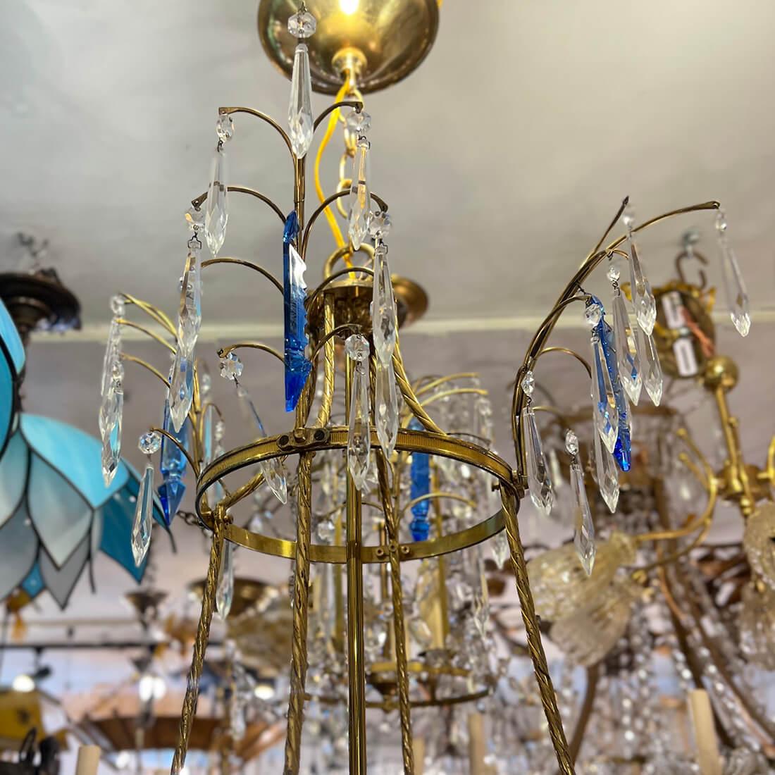 A circa 1900's gilt bronze Baltic chandelier with 8 candelabra lights with Clear and Blue crystal pendants and cut glass body inset.

Measurements: 
Diameter: 40