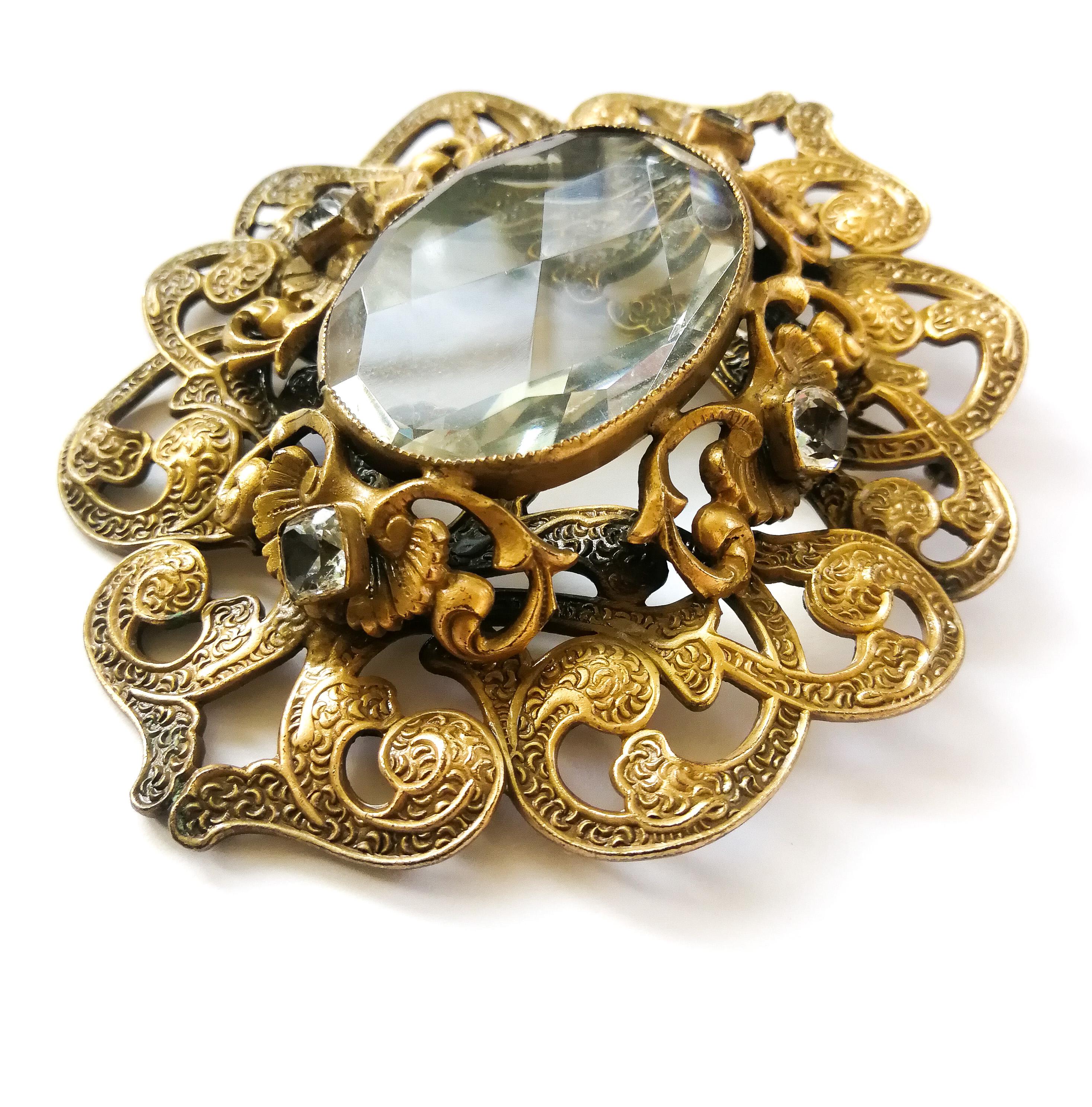A large and exceptional brooch from Joseff of Hollywood, dating from the 1940s, and made from antique 'Russian' gilded metal, with a beautiful central crystal stone, which is softly faceted. The metal work is beautifully textured, in a soft swirling