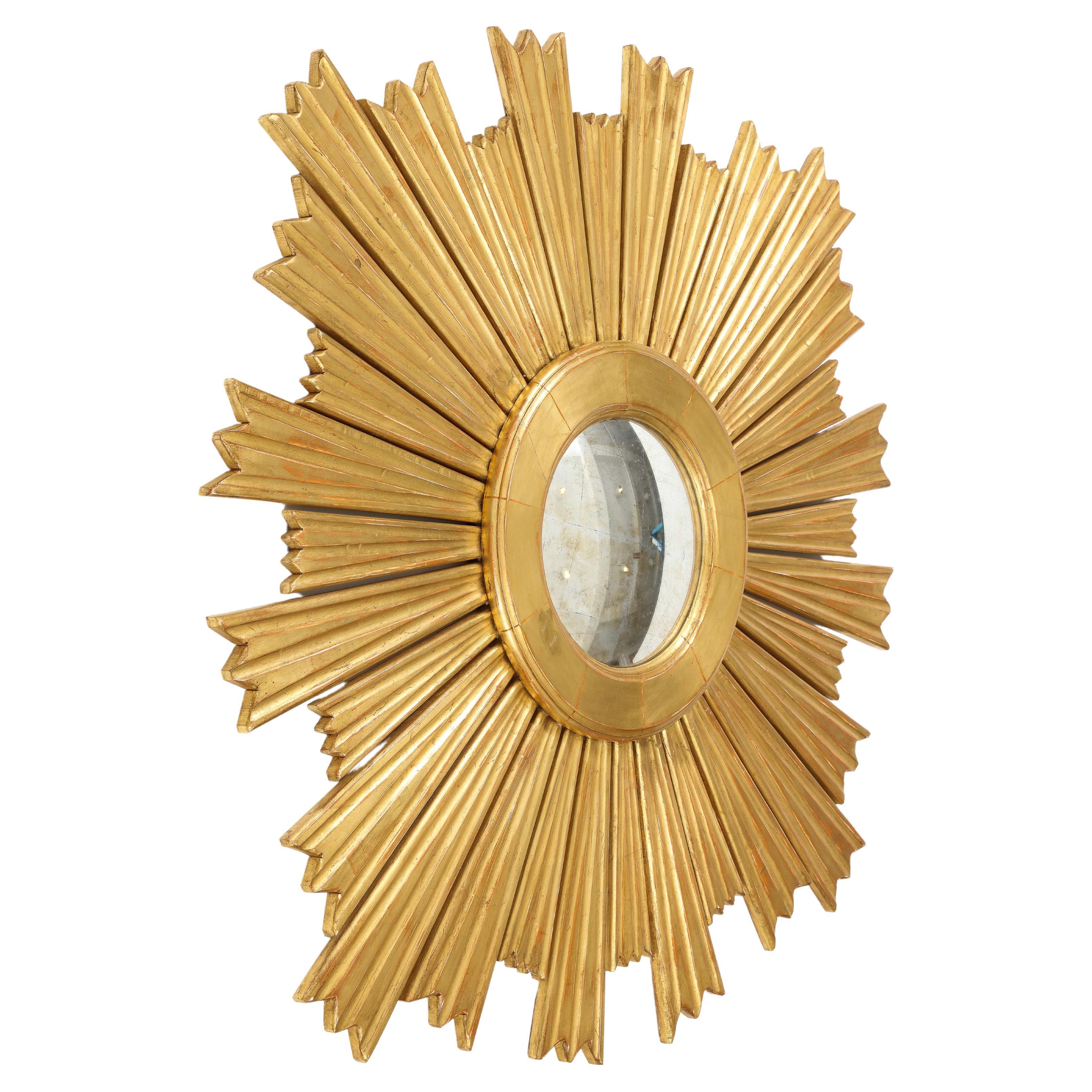A stunning giltwood sunburst mirror with graduated carved rays emerging from a molded center ring.  It's large scale would create a statement in any room. 