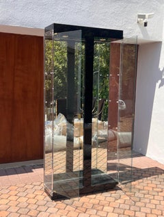 Un grand meuble curio en verre avec des accents noirs, laiton et miroirs, 20e siècle