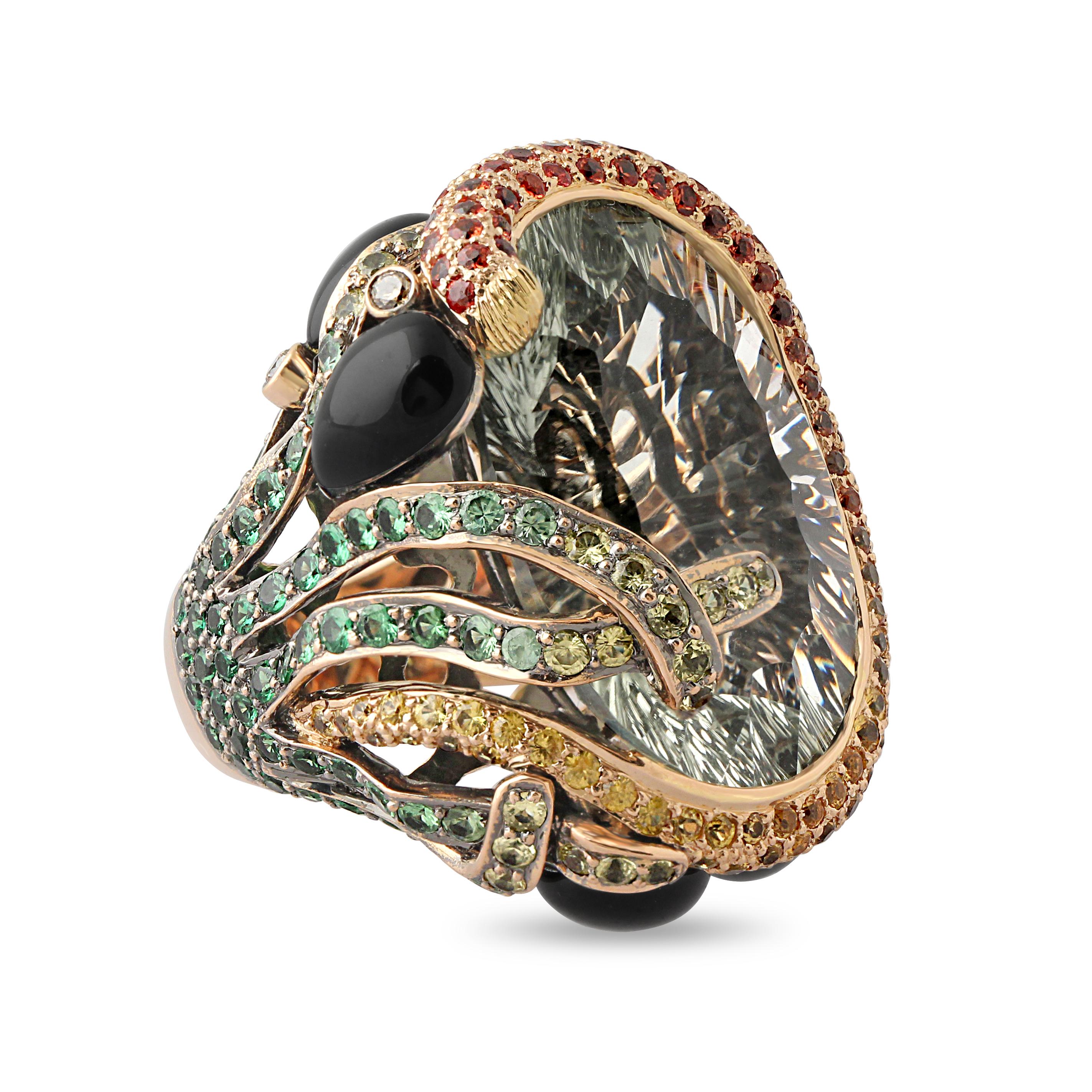 A striking gold and gem-set cocktail ring. Set at the centre with a large light green quartz surrounded by onyx, coloured sapphires and green garnet. Weight = 33.4 gr. Origin: French