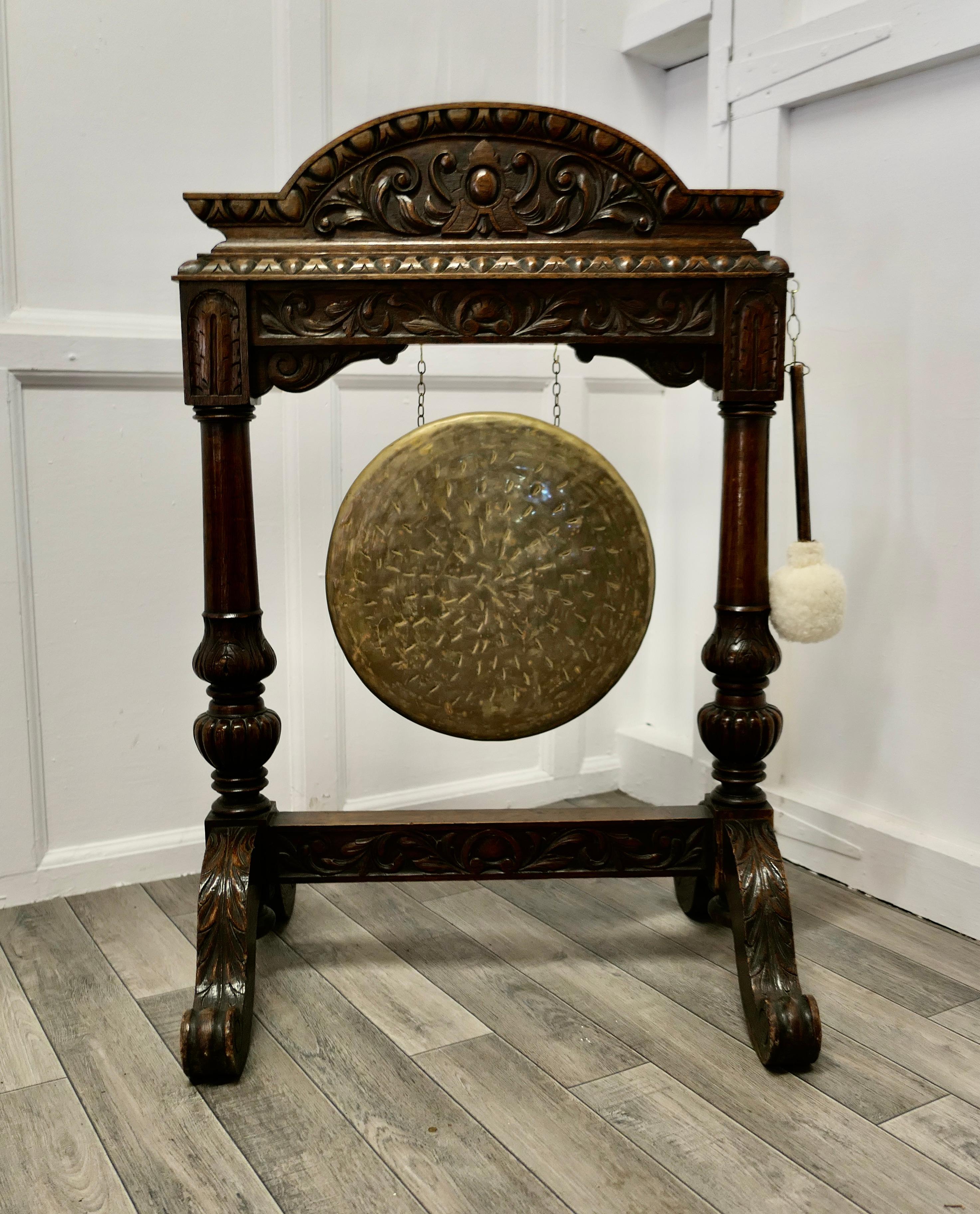 A large Gothic carved oak and brass dinner gong
 
This is a large piece the Large Brass Gong is suspended in an attractive and sturdy carved Oak stand, which unusually is carved on both sides, the Brass Gong has a good deep bong and will call your