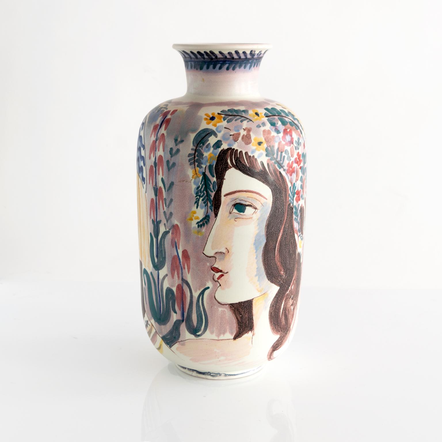 A large hand decorated ceramic vase by Carl-Harry Stalhane for Rorstrand. The vase depicts two women, one playing a flute or piccolo, the background has a tree, birds and lots of flowers. Signed on bottom made in 1944.
 