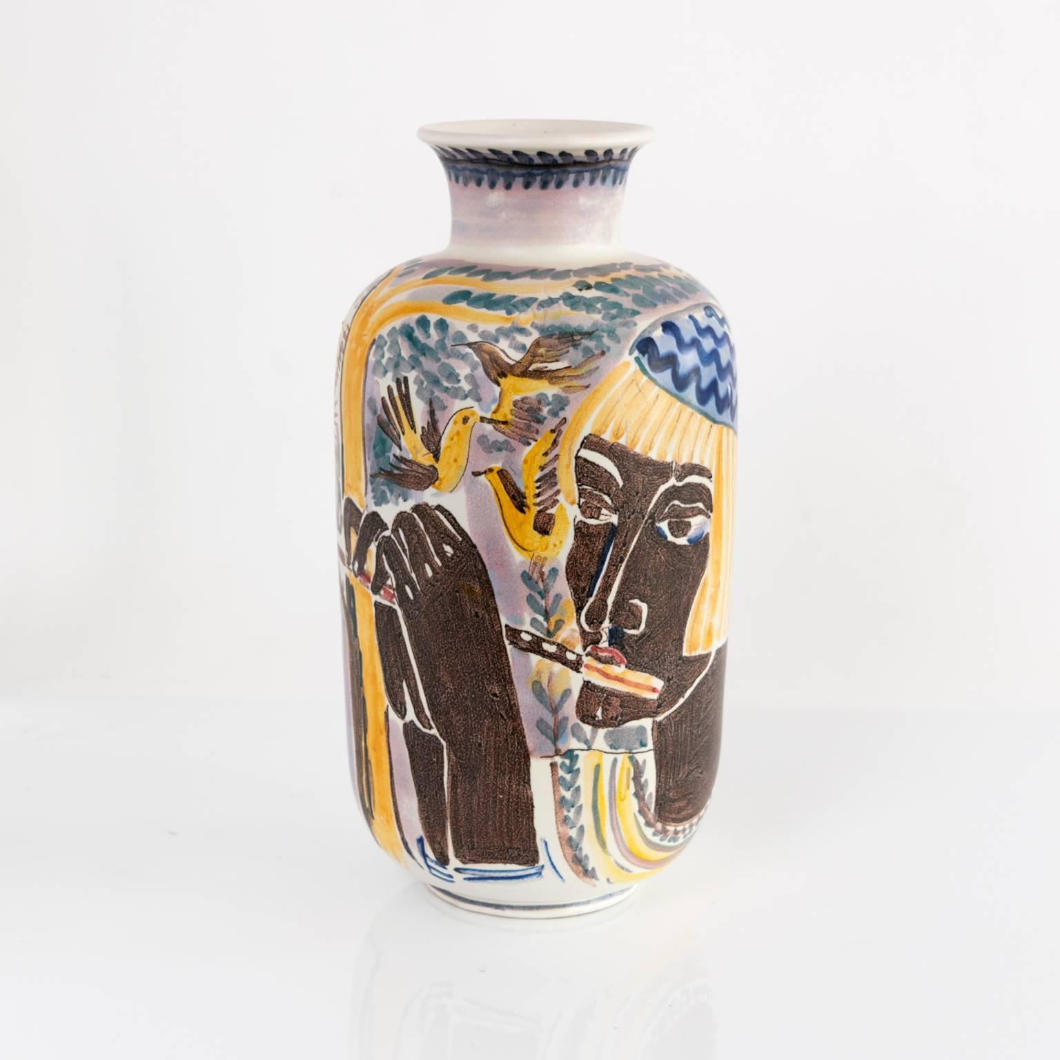 A large hand decorated ceramic vase by Carl-Harry Stalhane for Rörstrand. The vase depicts two women, one playing a flute or piccolo, the background has a tree, birds and lots of flowers. Signed on bottom made in 1944.

Measure: Height 16“ x