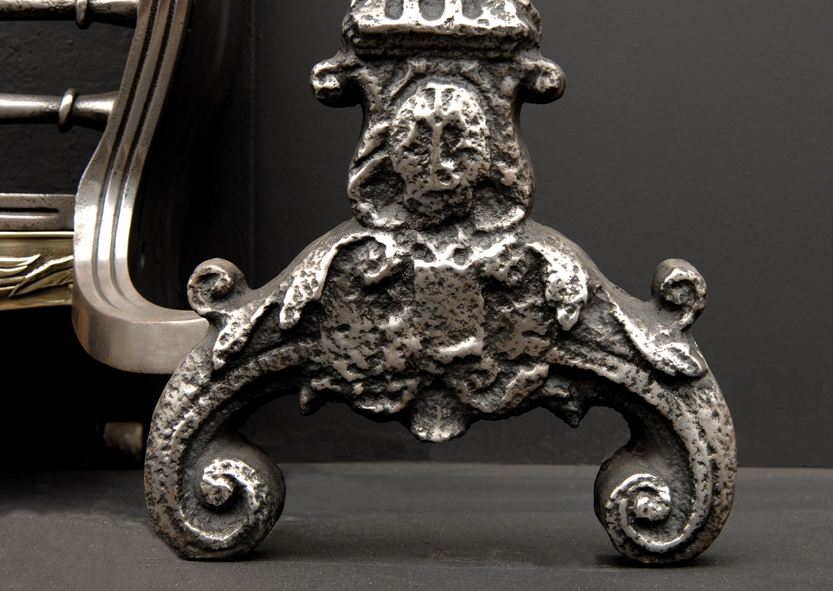 A large and imposing Victorian firegrate. Polished cast iron firedogs with scrolled bases and masks, cast brass fret and ornate iron back with scrolls, shell and foliage. Mid to late 19th century.

Measures: Width at front: 1145 mm 45 ?