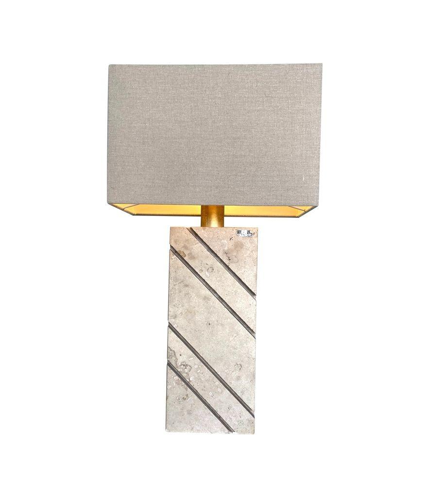 A large 1970s Italian travertine lamp by Cerri Nestore with a groove diagonal detail cut into the travertine on both sides, with brass stem and re wired with new brass fittings, antique gold cord flex and switch. With new bespoke linen shade and