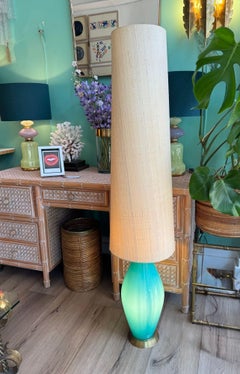 A large Italian 1960s turquoise glass floor lamp with orignal hessian shade