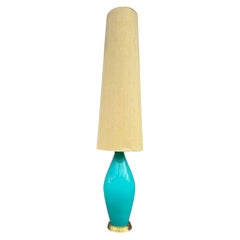 A large Italian 1960s turquoise glass floor lamp with orignal hessian shade