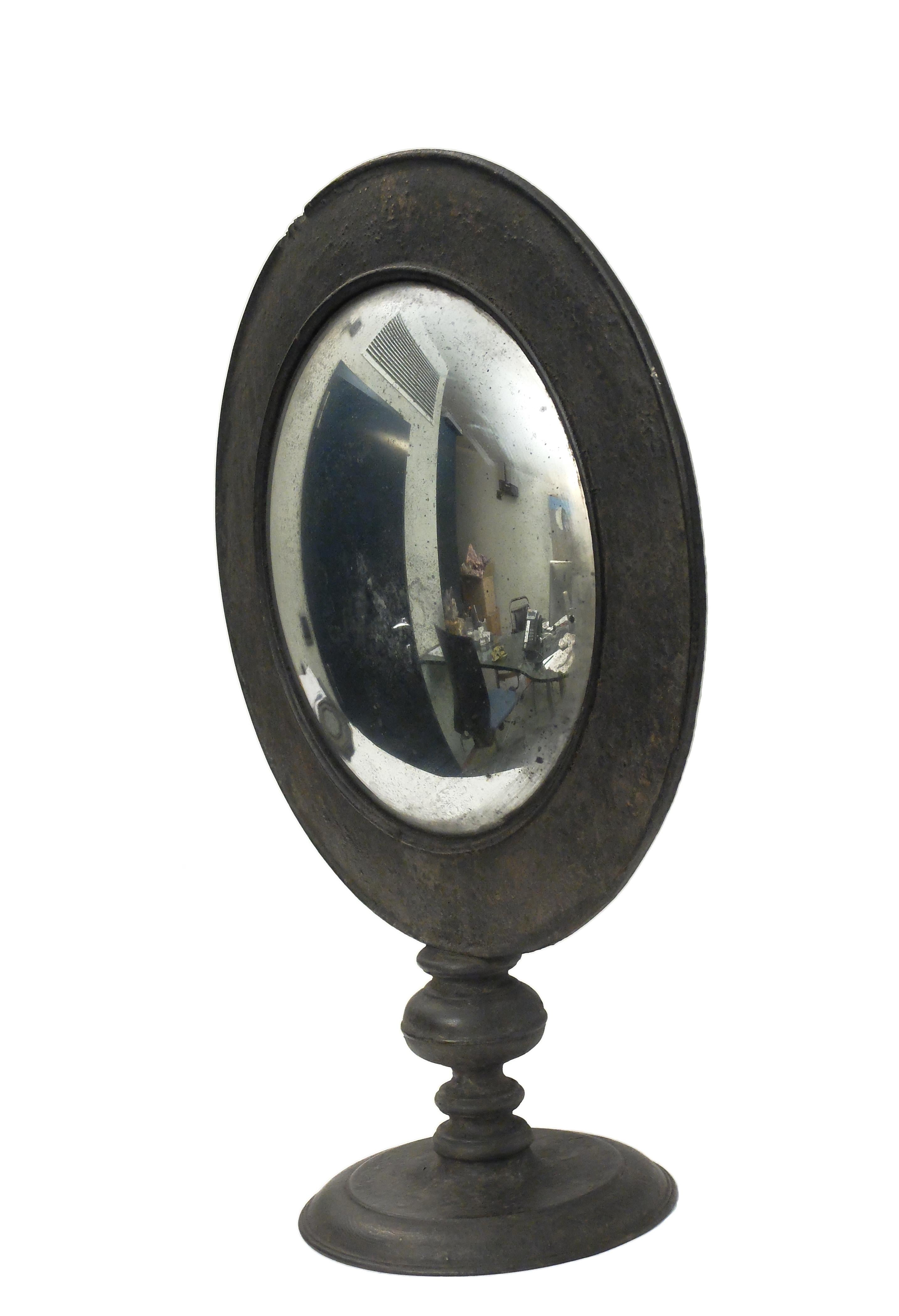 A large Wunderkammer convex round table mirror with black wooden frame, mounted over a black round wooden base.