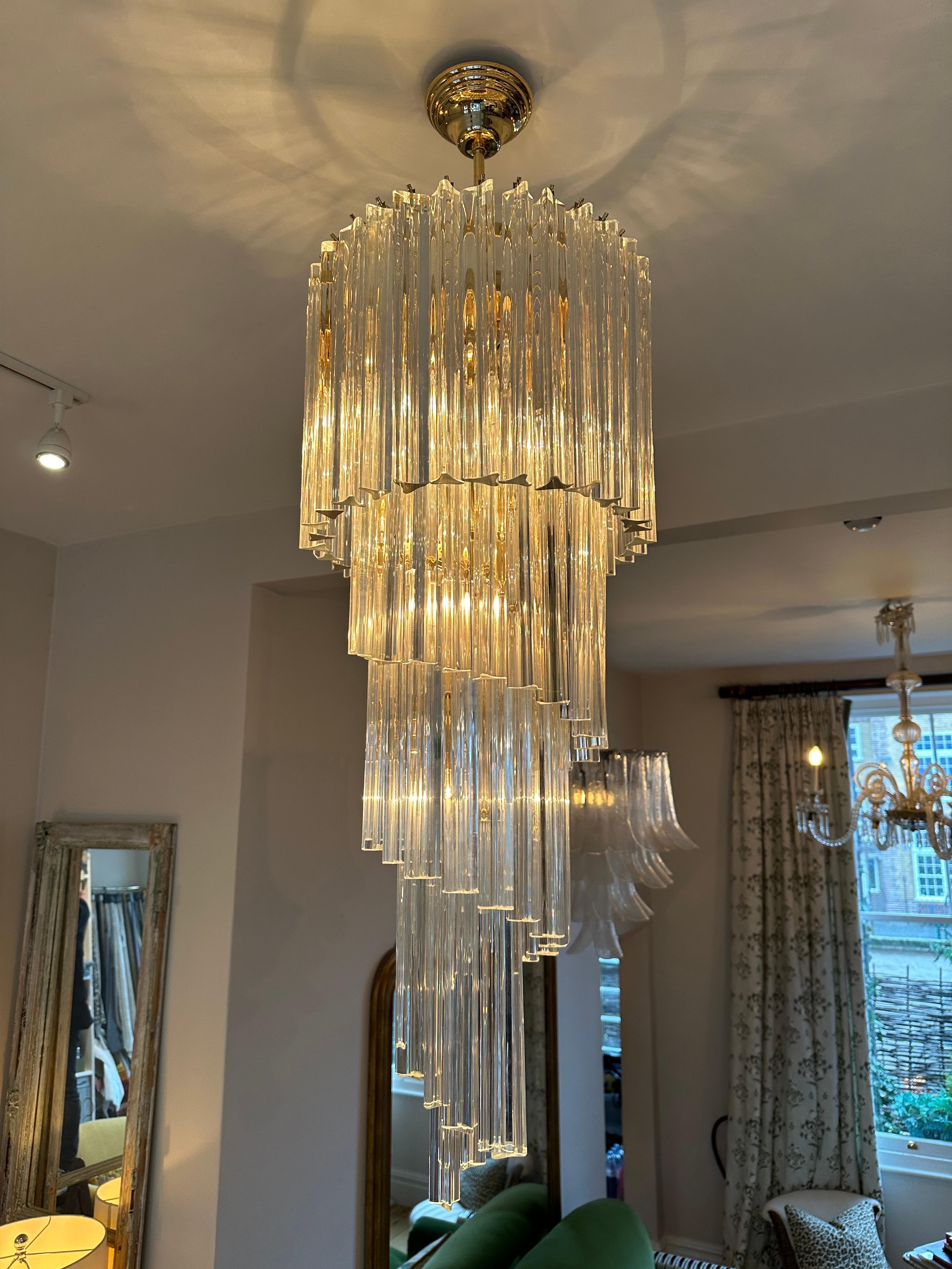 Un grand lustre suspendu en spirale en verre clair de Murano, fabriqué par les fabricants italiens Novaresi. Suspendu à un cadre laqué or avec une chute de 120 cm avec la rosace de plafond et la chaîne, le luminaire actuel a une hauteur de 90 cm.