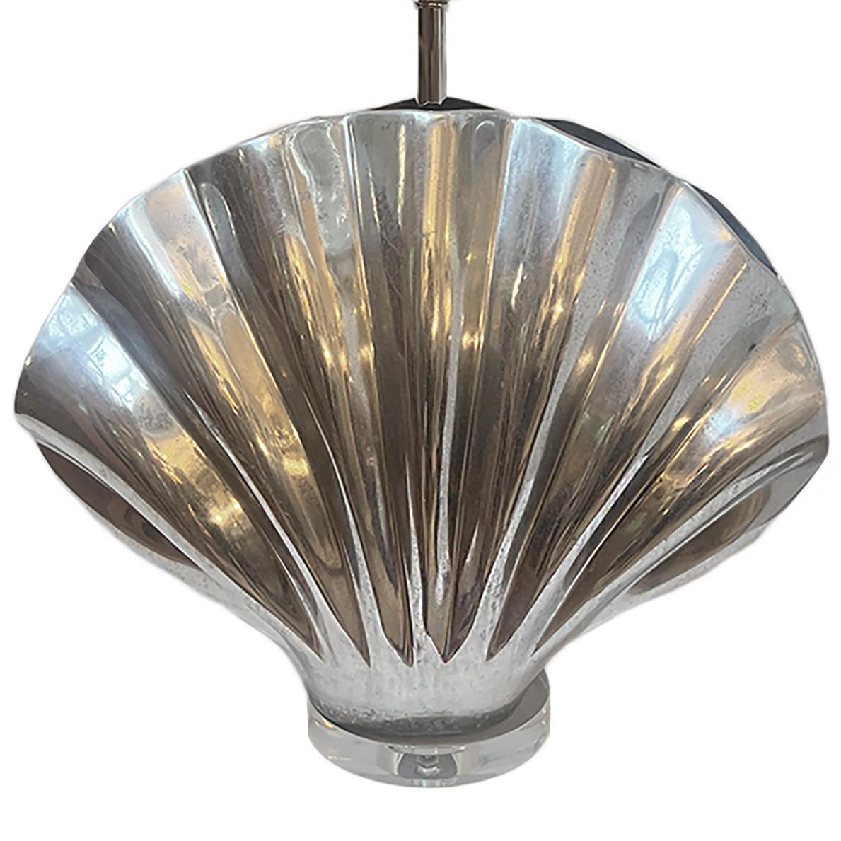 Lámpara de sobremesa de aluminio en forma de concha de la década de 1960, con base de lucita.

Medidas:
Altura del cuerpo: 17,75
Altura hasta el apoyo de la sombrilla: 30.75
Anchura: 19
Profundidad: 7