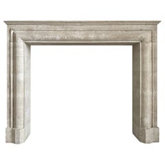 A large Italian Travertine Stone Bolection Fireplace Mantel