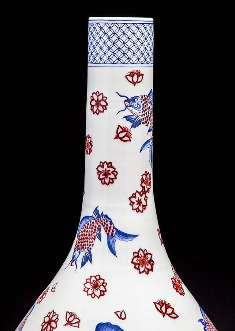 A large Japanese Imari vase
Of baluster form with a long narrow neck enameled in underglaze blue and iron red with catfish and flowers; signed.
Measures: Height 30 in. (76.2 cm.)
Width 15 in. (38.1 cm.) 
Diameter of top rim 3.5 in. (8.89 cm.)
 