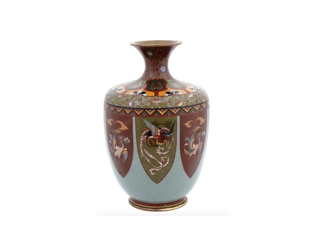 Vaso di cloisonne giapponese di ottima qualità con bordo svasato, collo sottile e corpo a balaustro. La superficie è smaltata con medaglioni policromi molto dettagliati che raffigurano uccelli Phoenix su un fondo blu chiaro e presenta bellissimi