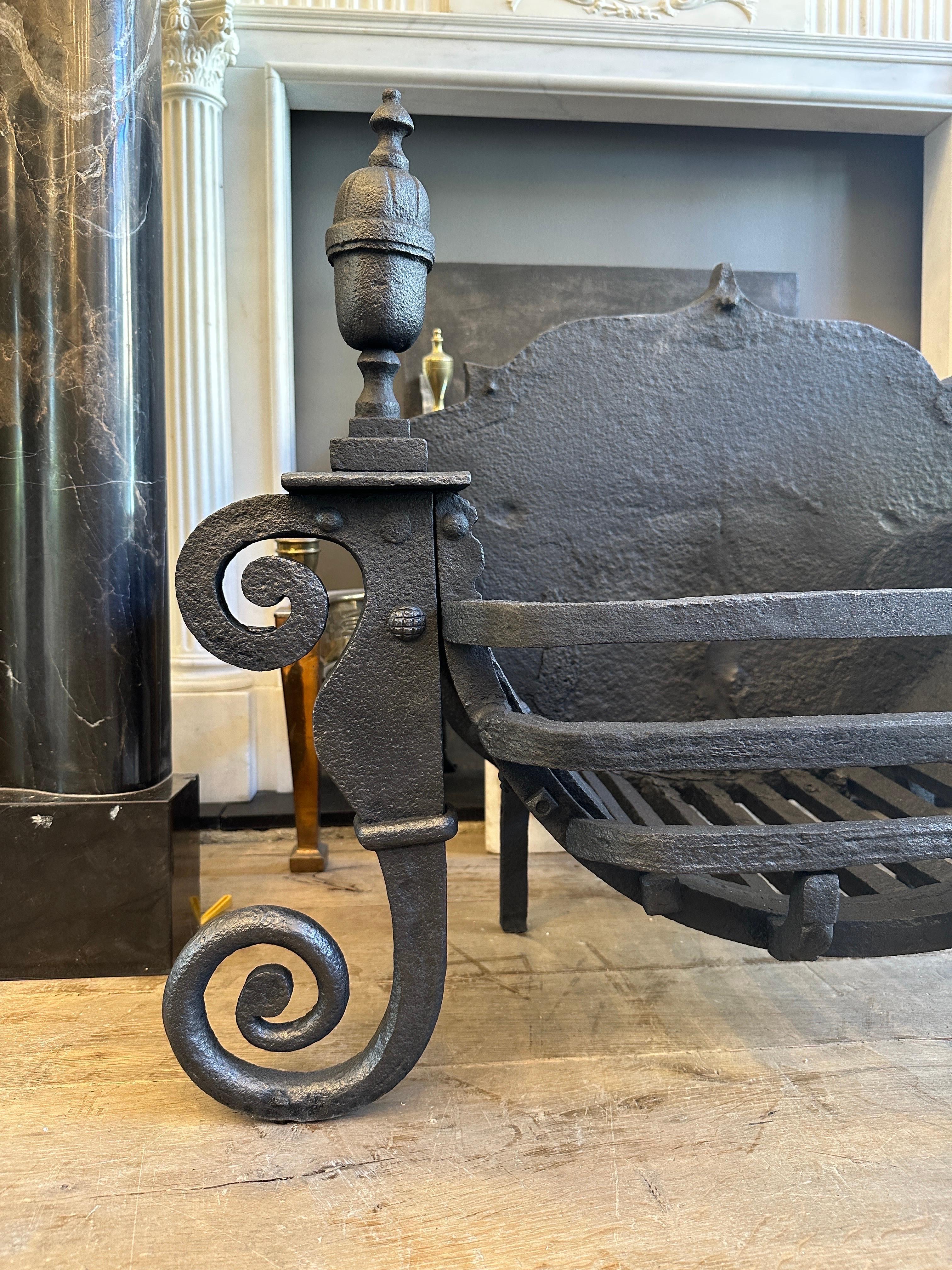 A large wrought iron fire basket/dog grate from the late 18th century George III period. Black lead polished, with C scrolled front supports, flanking a curved swans nest burning area of quite large proportions. Simple shaped bars, surmounted by