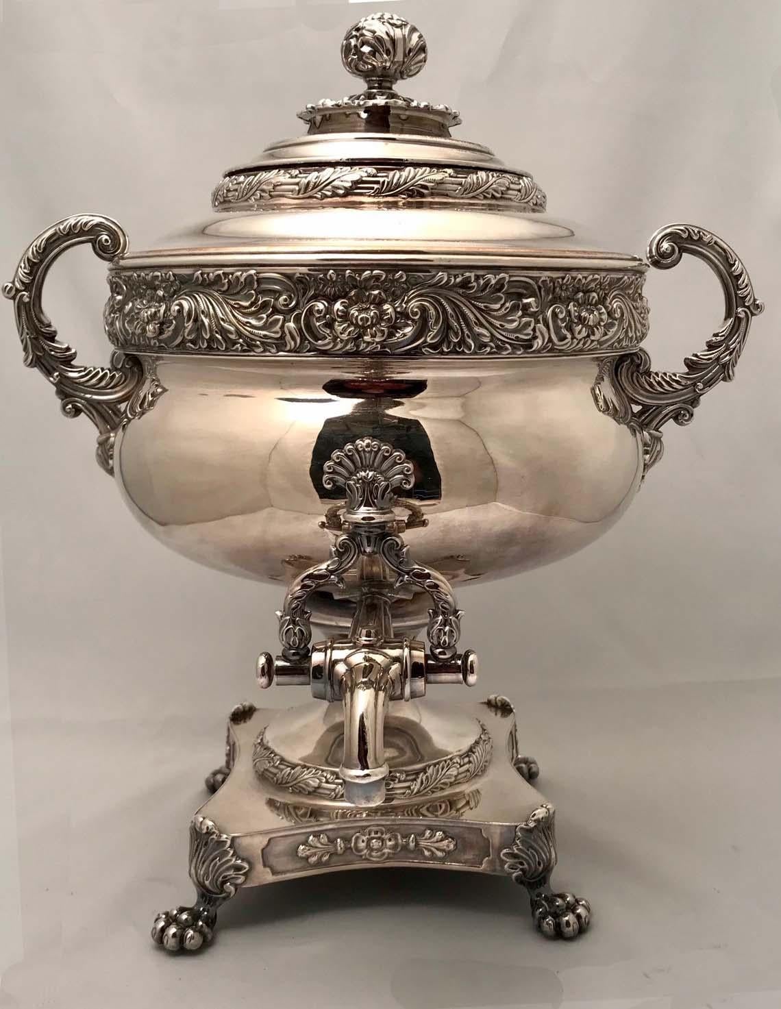 This is a splendid example of the form. that breaks away from  Neo-Classical plainness into exuberant and lively ornament. The two handled urn is banded with leaves and acanthus. The shaped rectangular base is supported by shell and lion-paw feet.