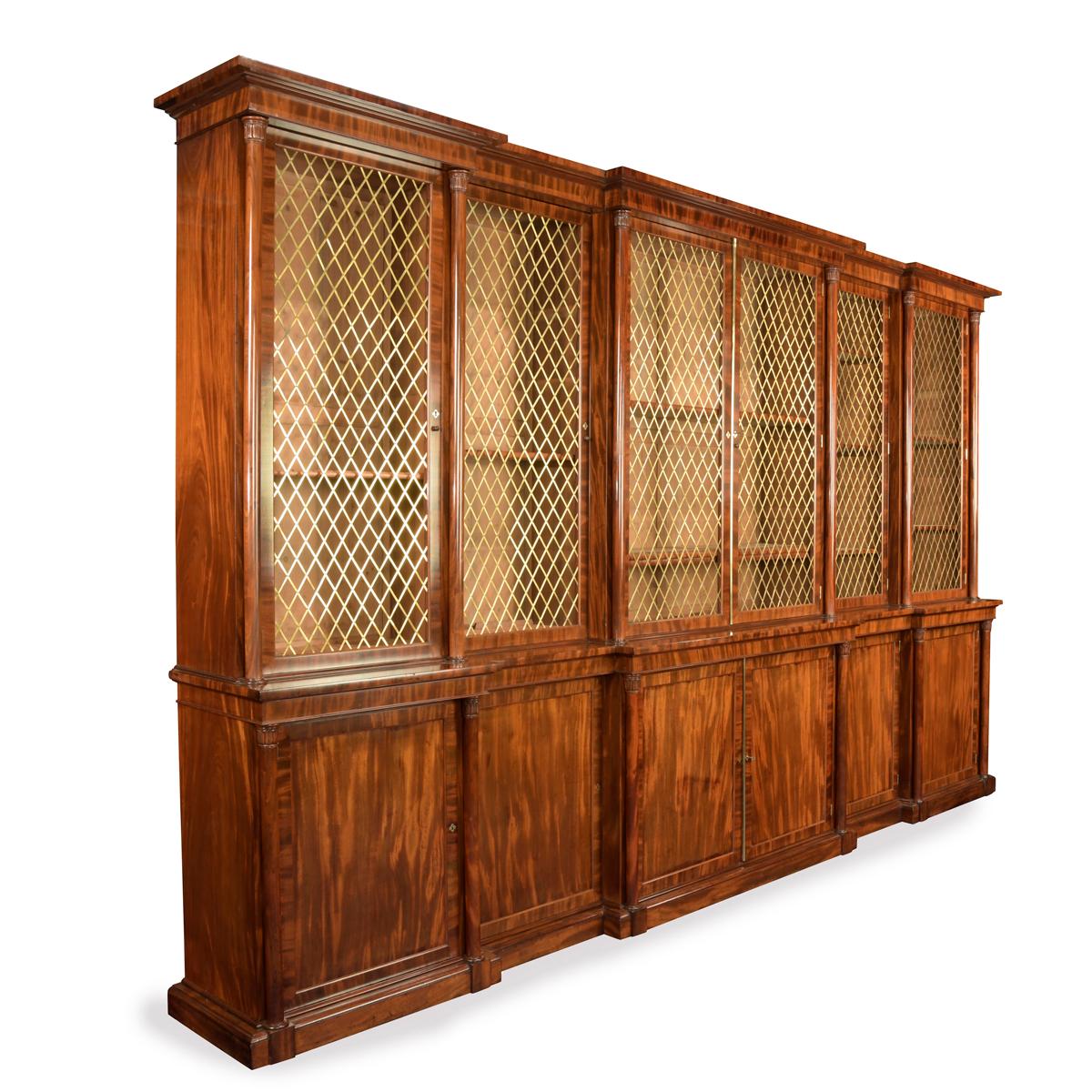 A large and impressive late Regency six door mahogany bookcase attributed to Gillows, the upper section with a triple breakfront cornice above glazed doors with brass diamond trellis grilles, each enclosing adjustable shelves, the base with panelled