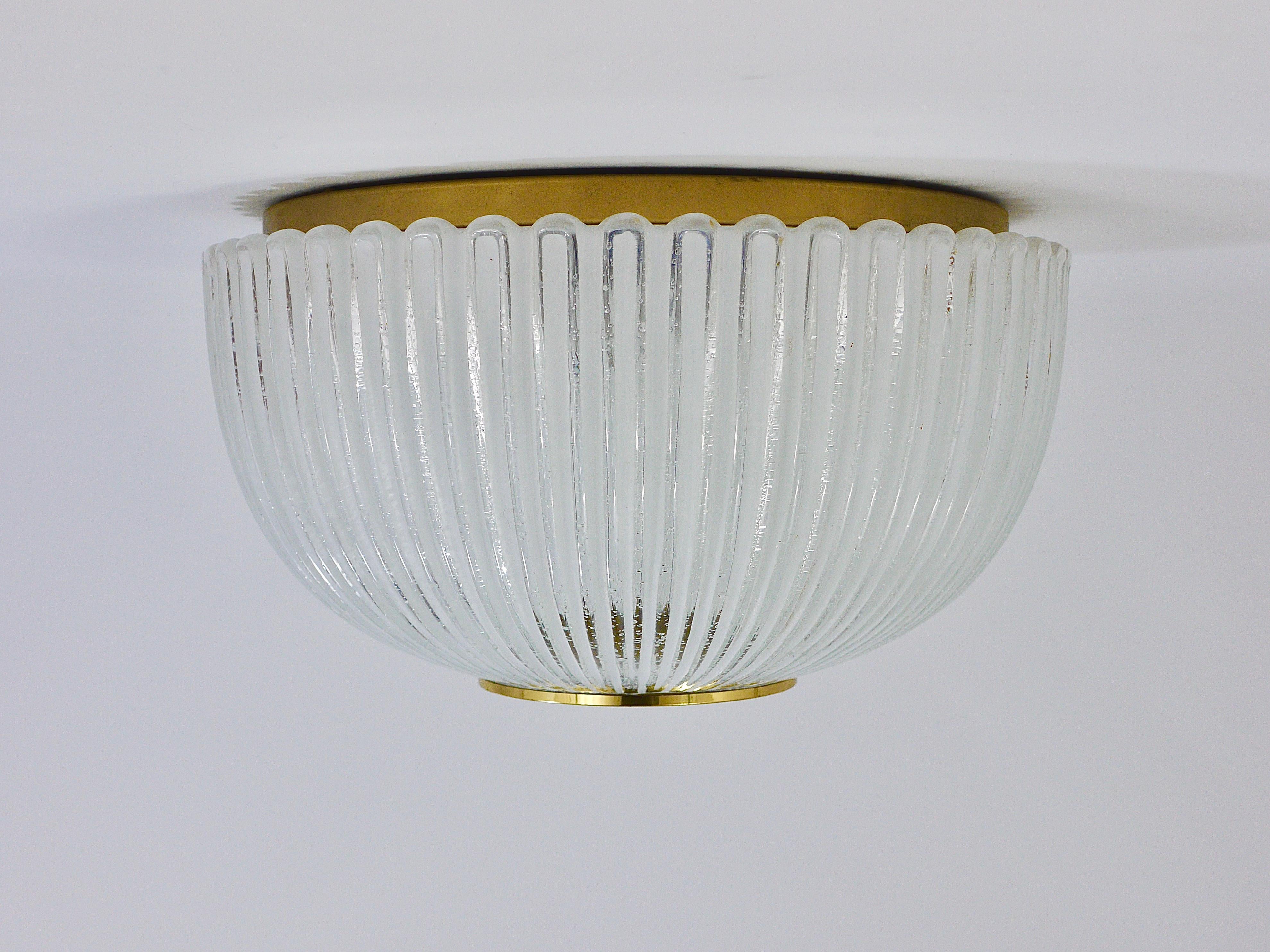 A beautiful and large hemispherical Midcentury ceiling light or flushmount from the 1970s, manufactured by Limburg Germany. This light has a diameter of 16 inches, its round striped lampshade is handmade of white and clear melting glass with tiny