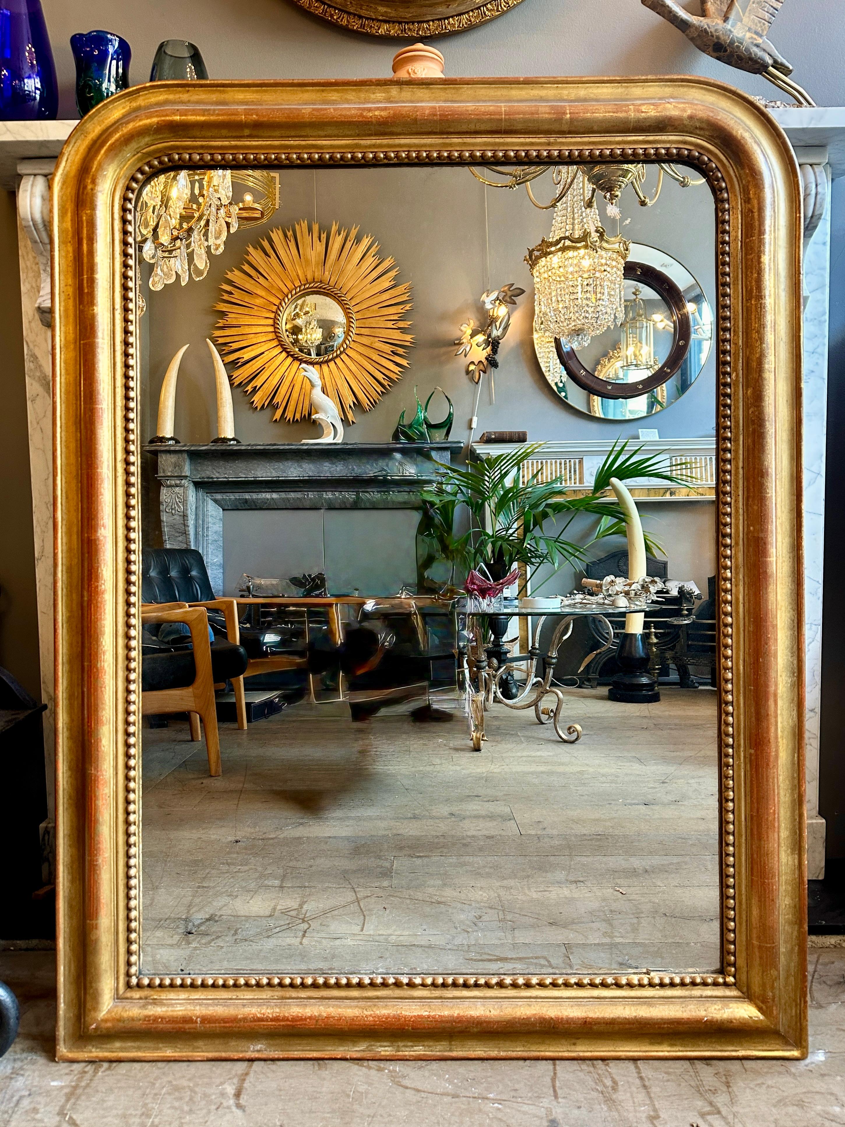 Un grand miroir doré français d'époque Louis Philippe, avec une plaque de miroir d'origine avec très peu ou pas de rousseur, une usure chaude et douce du travail de dorure. Slip intérieur perlé. Embarquement de retour. Un très bon exemple de ce type