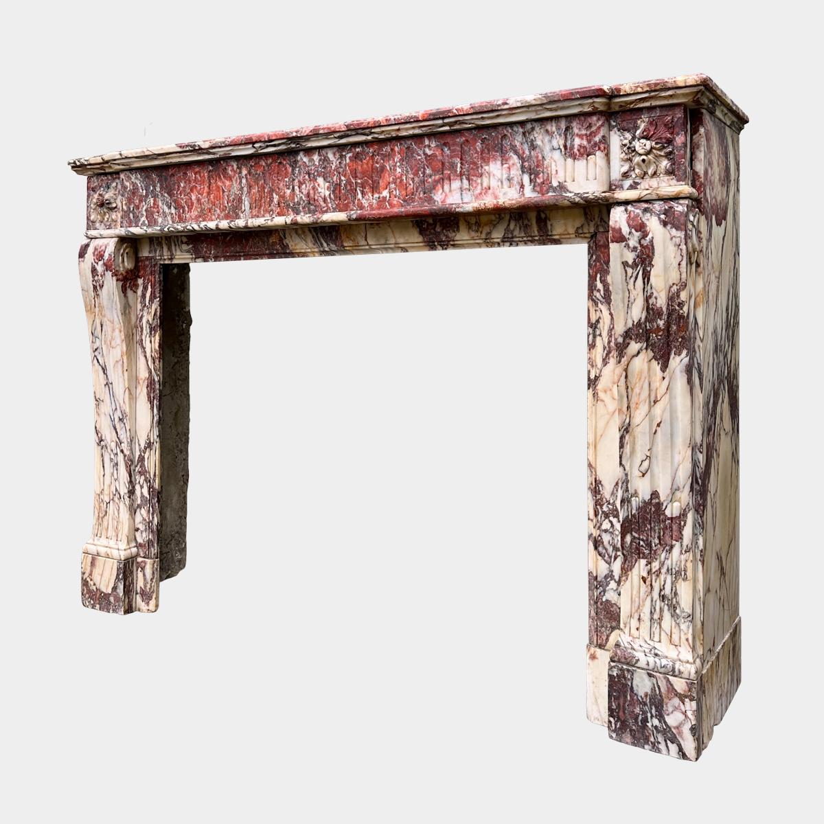 Grande cheminée en marbre de la Brèche de Saint Maximin, très panachée, de la toute fin du XVIIIe siècle. Riche en couleurs de pourpre, de crème, de blanc, d'or et de rouge profond. Les montants de la console sont cannelés avec des blocs d'extrémité