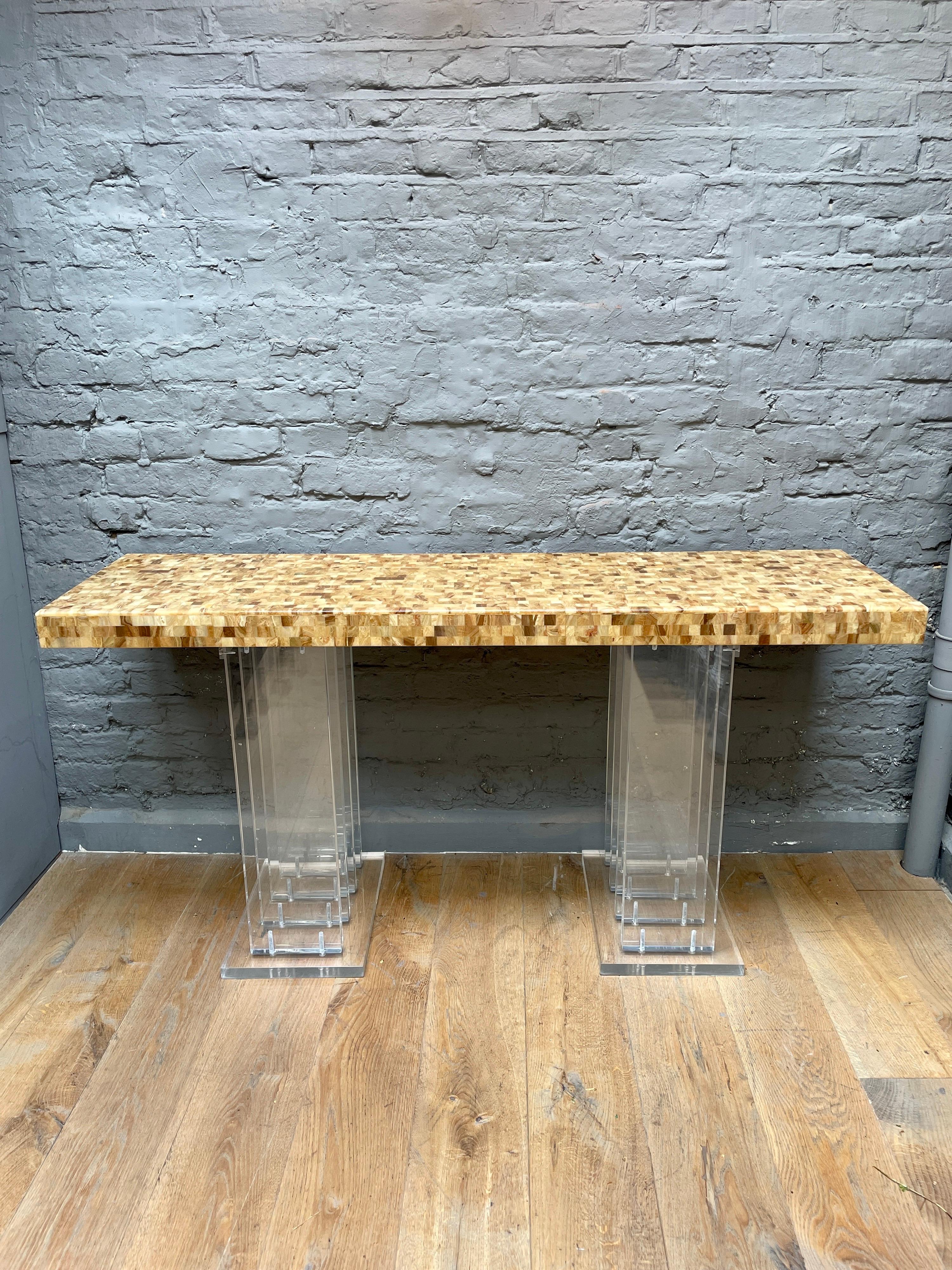 A large unusual console table with lucite plinth supports and a stylised epoxy resin and segmented wooden top. 
Continental circa 1980.