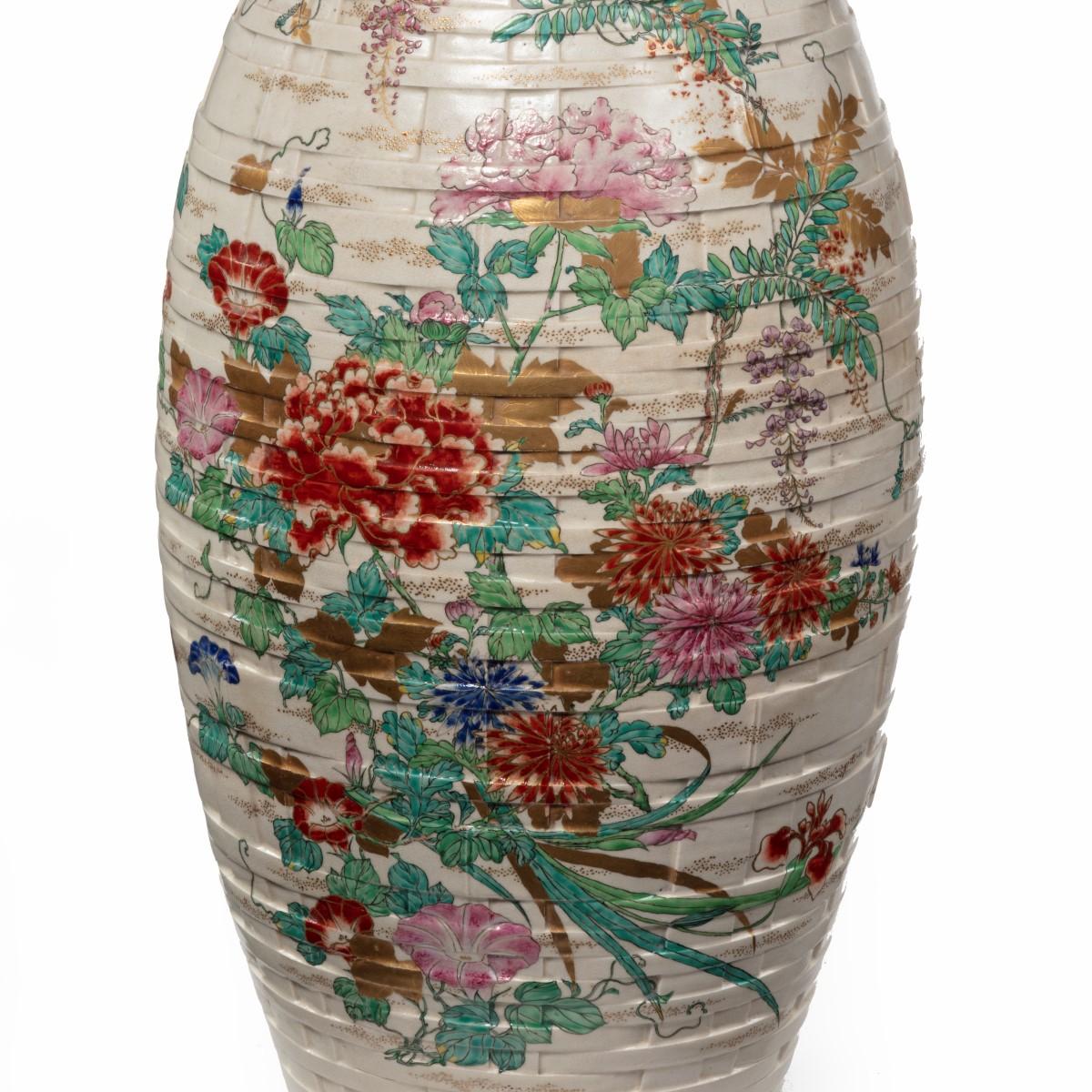 A large Meiji period Satsuma earthenware floor vase, the of baluster form, painted in pastel overglaze enamels and gilding with two large sprays of flowers including prunus blossom, carnations, tiger-lilies, wistaria, peonies and petunias, the neck