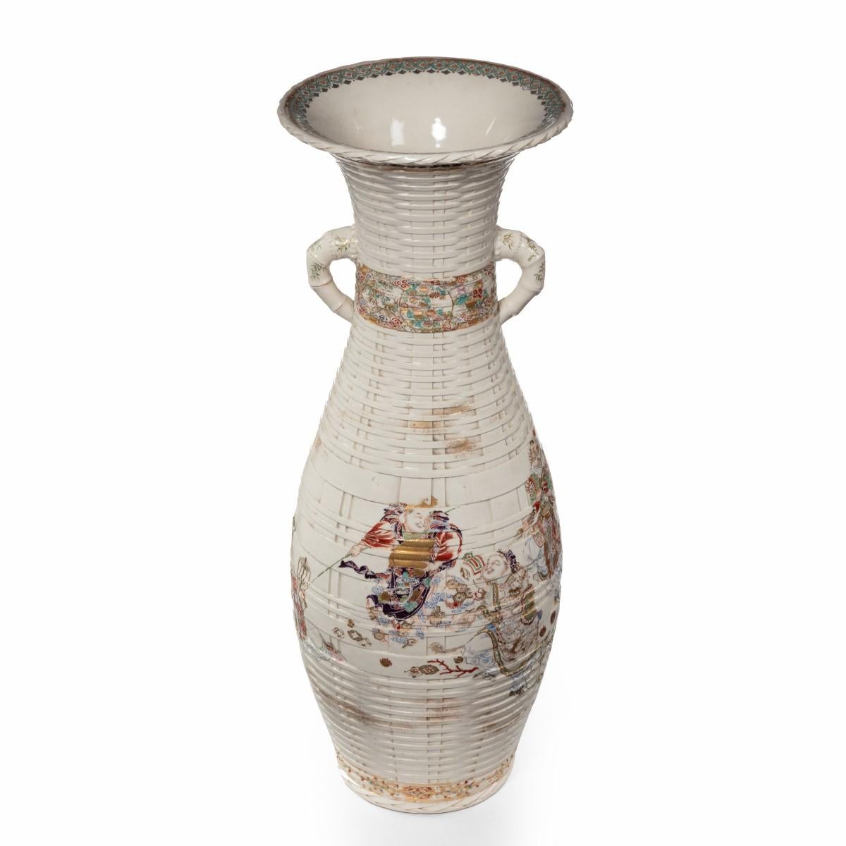 A large Meiji period Satsuma earthenware floor vase, the skittle shaped body painted in pastel overglaze enamels and gilding with a continuous frieze of the Seven Gods of Good Fortune on an intricate basketweave ground. Japanese, circa 1875.

For
