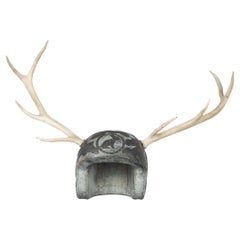 A large metal helmet with applied stag antlers by Martin Scorey