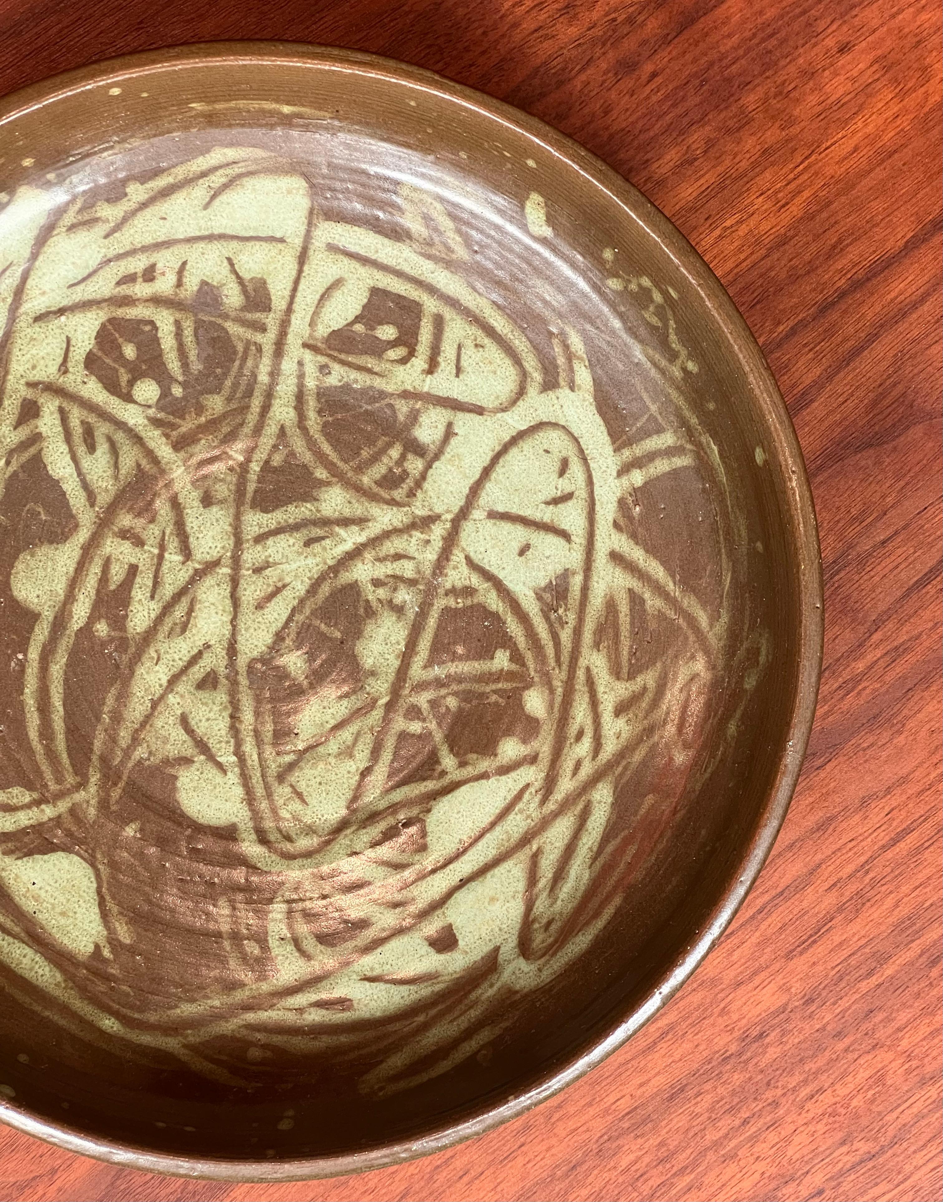Eine atemberaubende und einzigartige handgefertigte Mitte des Jahrhunderts moderne Studio Art Keramik Obstschale oder Teller, circa 1960. Glasierte Töpferware in gedeckten Oliv- und Meerschaumtönen.