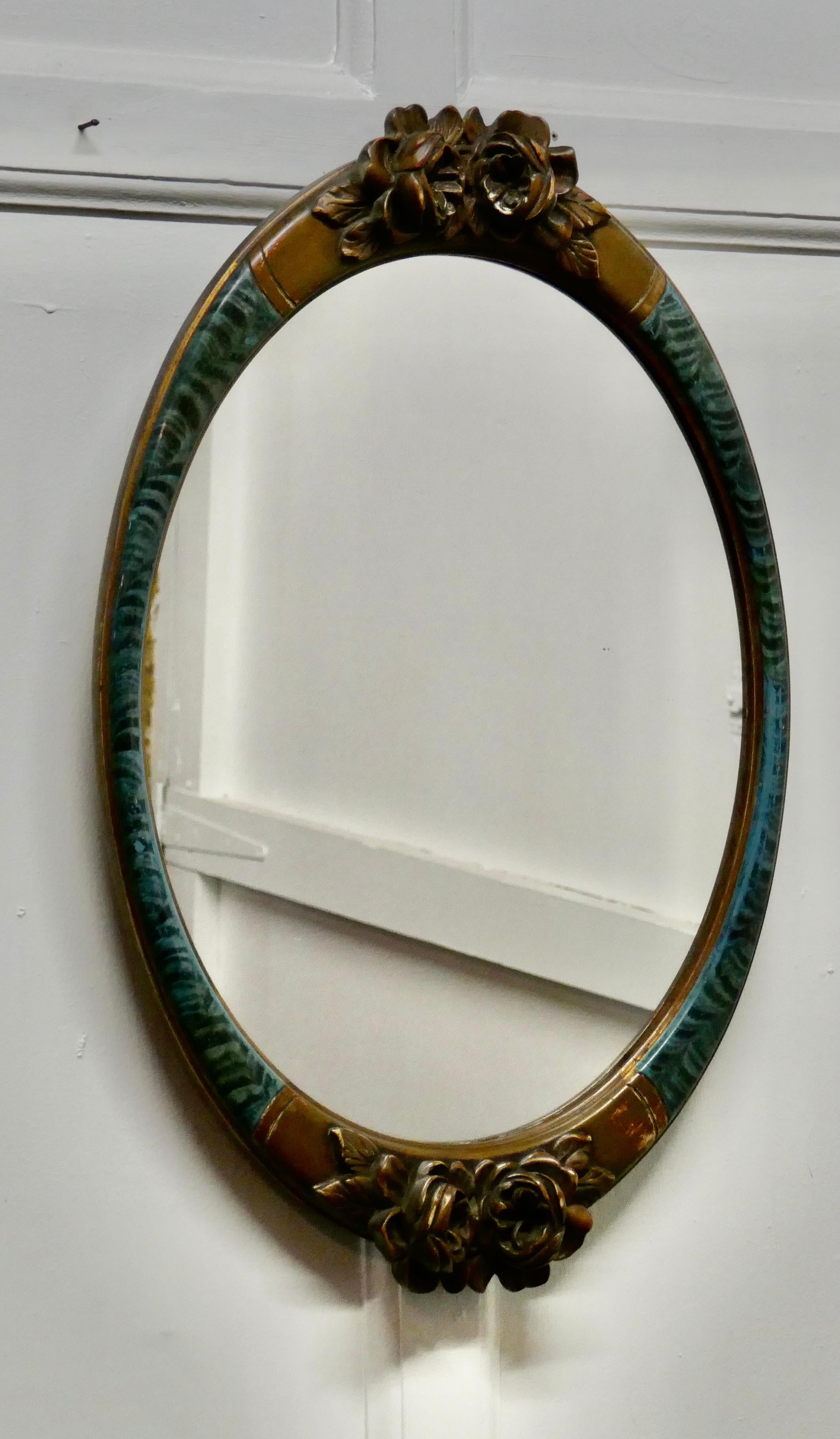 A large mirror in oval ormolu frame

This handsome mirror frame comes from Brest in France
The frames is in a blue oyster veneer with large ormolu roses at the top and bottom of a truly unusual superb frame

The frame is 26” high and 17”