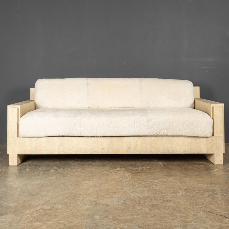 An iconic Art Deco style sofa panelled in cream shagreen with shearling upholstered bolster cushion and seat. One of the first creations by R&Y Augousti of Paris, c. 1990. R&Y Augousti was founded in 1989 by husband-wife duo Ria & Yiouri Augousti.