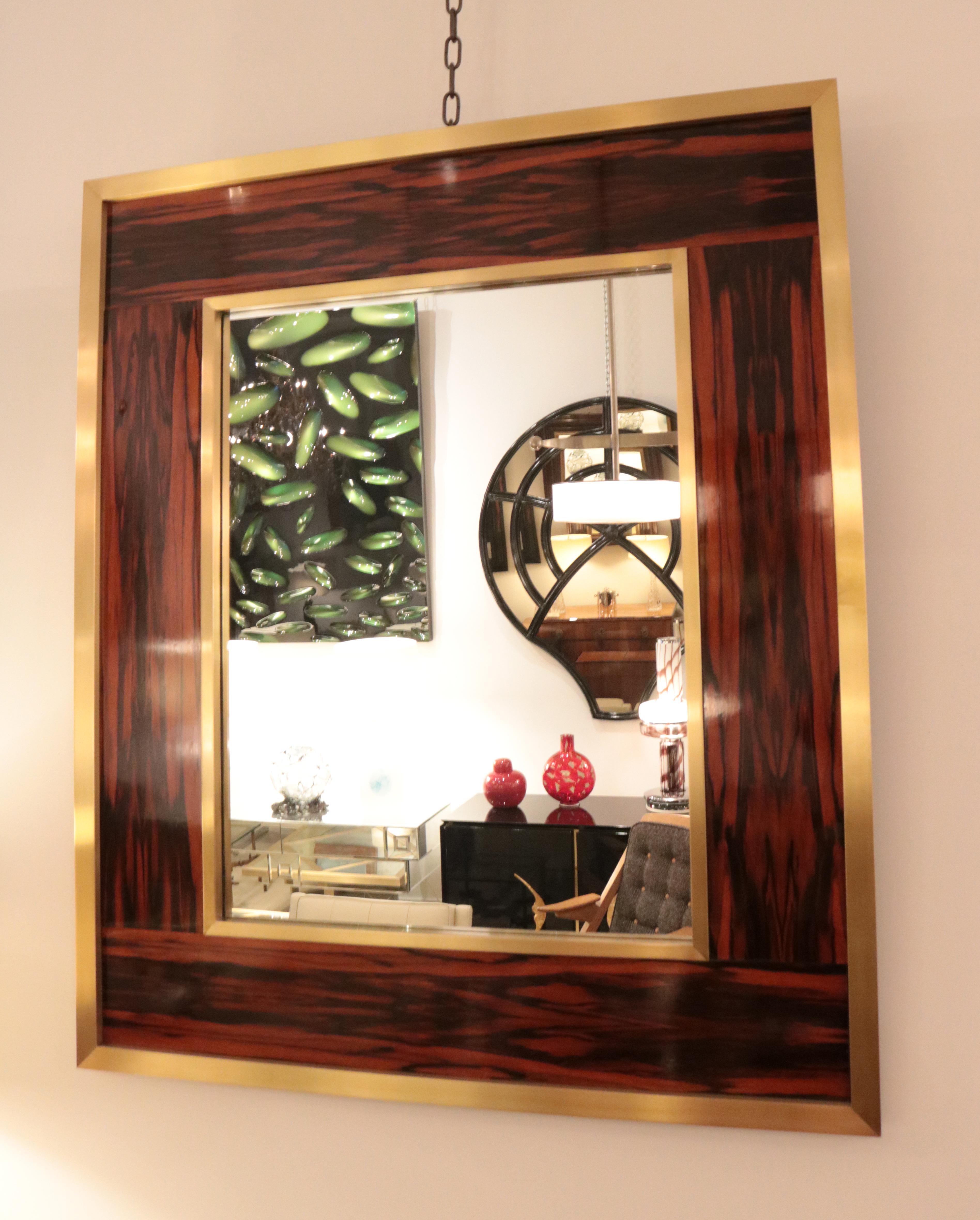 A large modernist wall mirror. 
Macassar with patinated brass details.

 