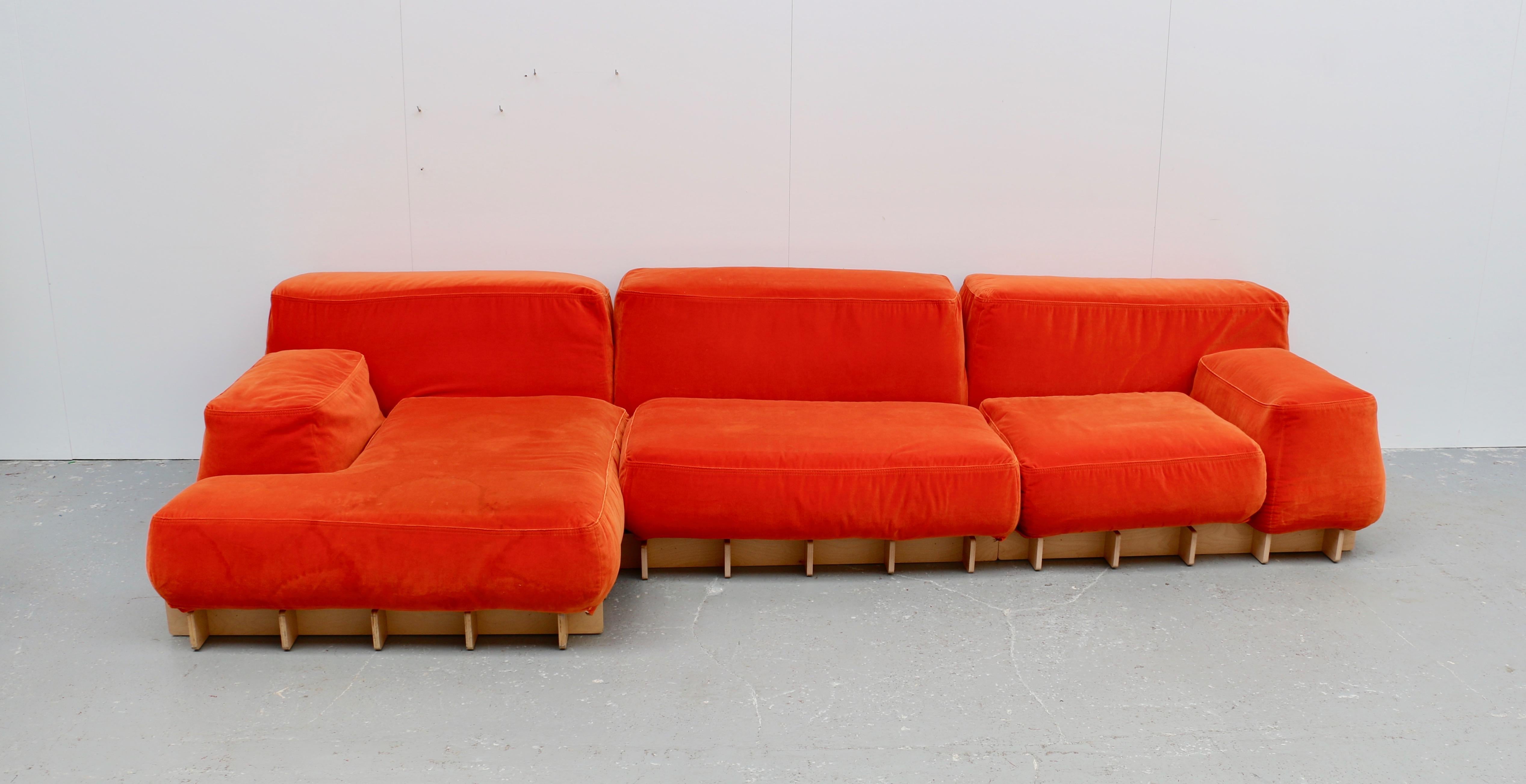 This large modular sofa is composed of a meridian, a lounge chair and an armchair on a light wood base. The color and the shape are very original and it's very confortable.