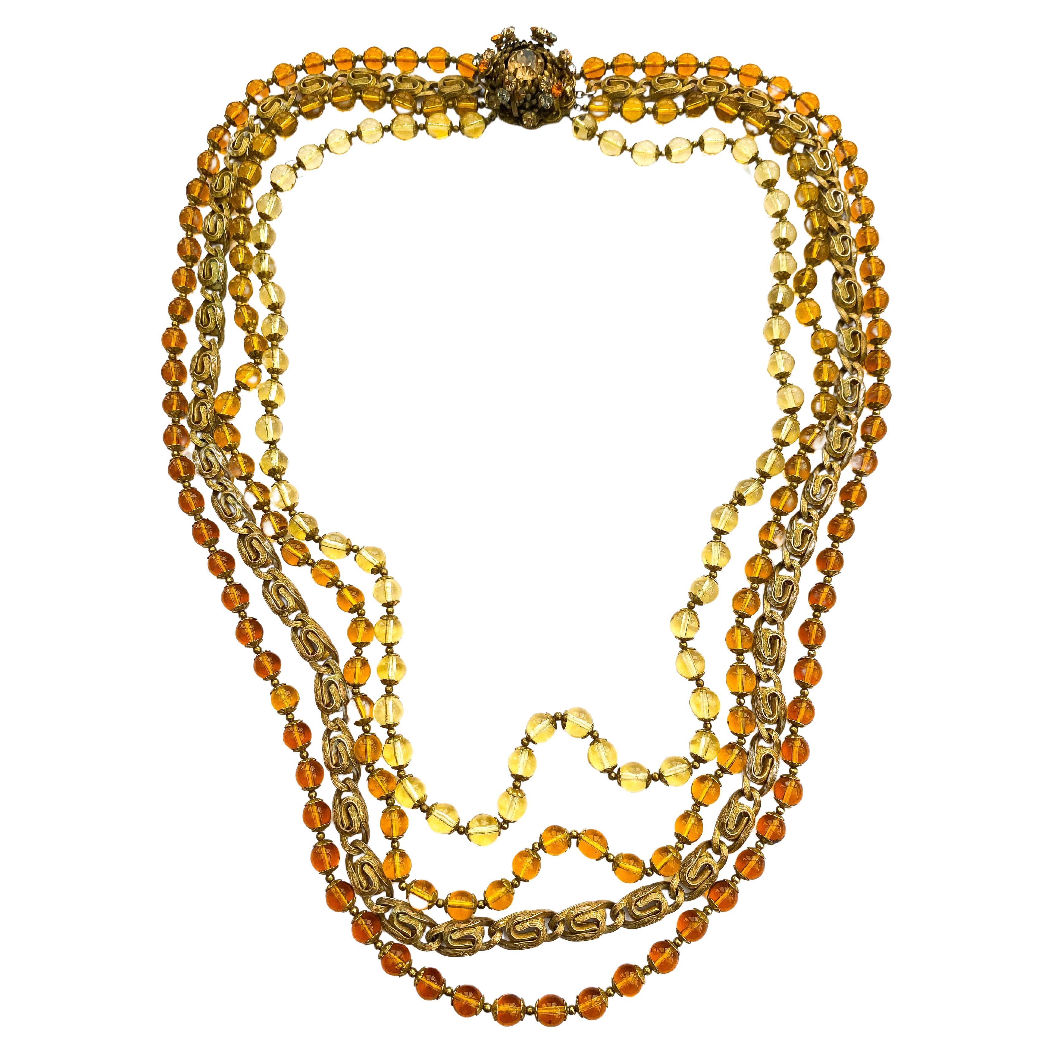 A striking and splendid show, this multi row glass bead and chain necklace, though unsigned, is undoubtedly Miriam Haskell, bearing all the hallmarks and composite elements characteristic of the celebrated designer. The decorative clasp in acorn or