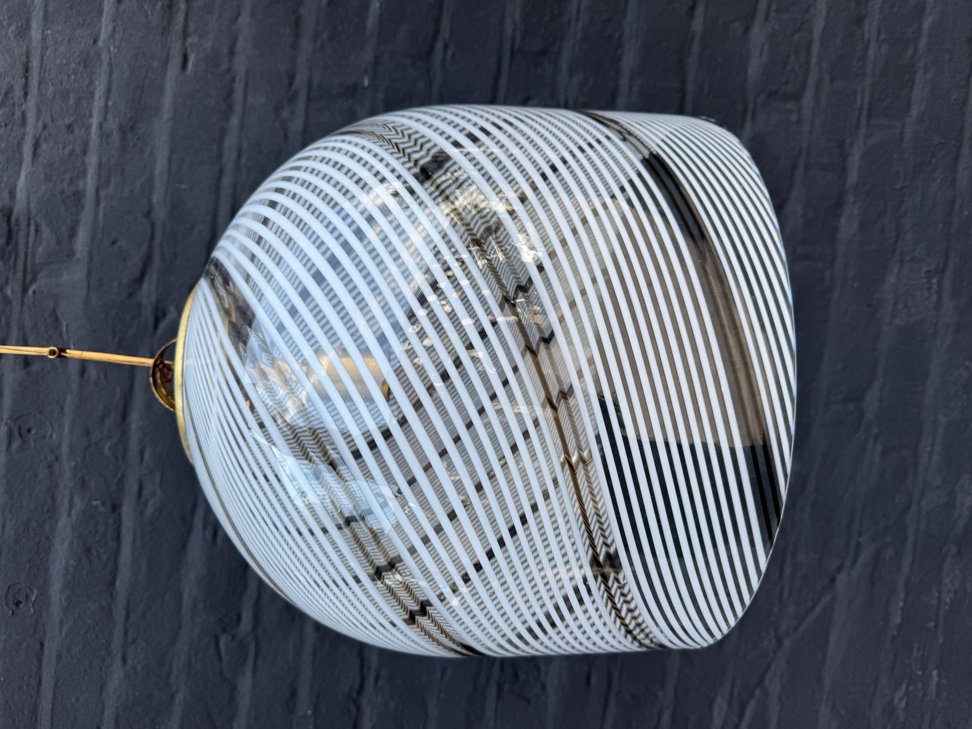 Gran lámpara colgante italiana de cristal de Murano de la década de 1970, de Venini, con diseño de remolinos de Tessuto en blanco y bronce, y fijación superior y rosetón de techo de latón. Recableado con racores de latón nuevos, flexo de cable