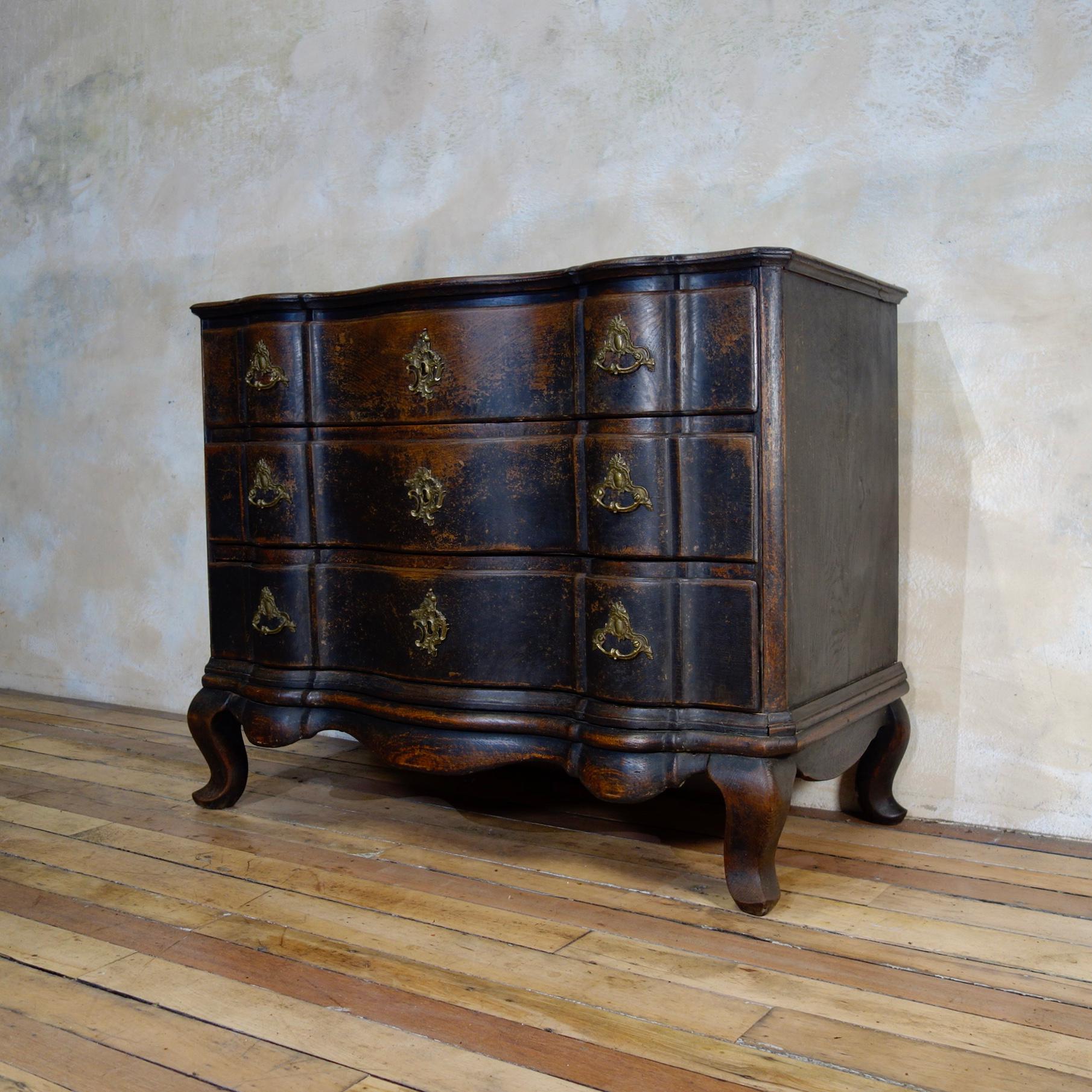 An elegant 18th century Danish Baroque commode. Demonstrating three full length serpentine drawers, Raised on monumental cabriole supports joined by an elegantly shaped apron. Displaying its original ebonized black paint. 

Measures:
Width