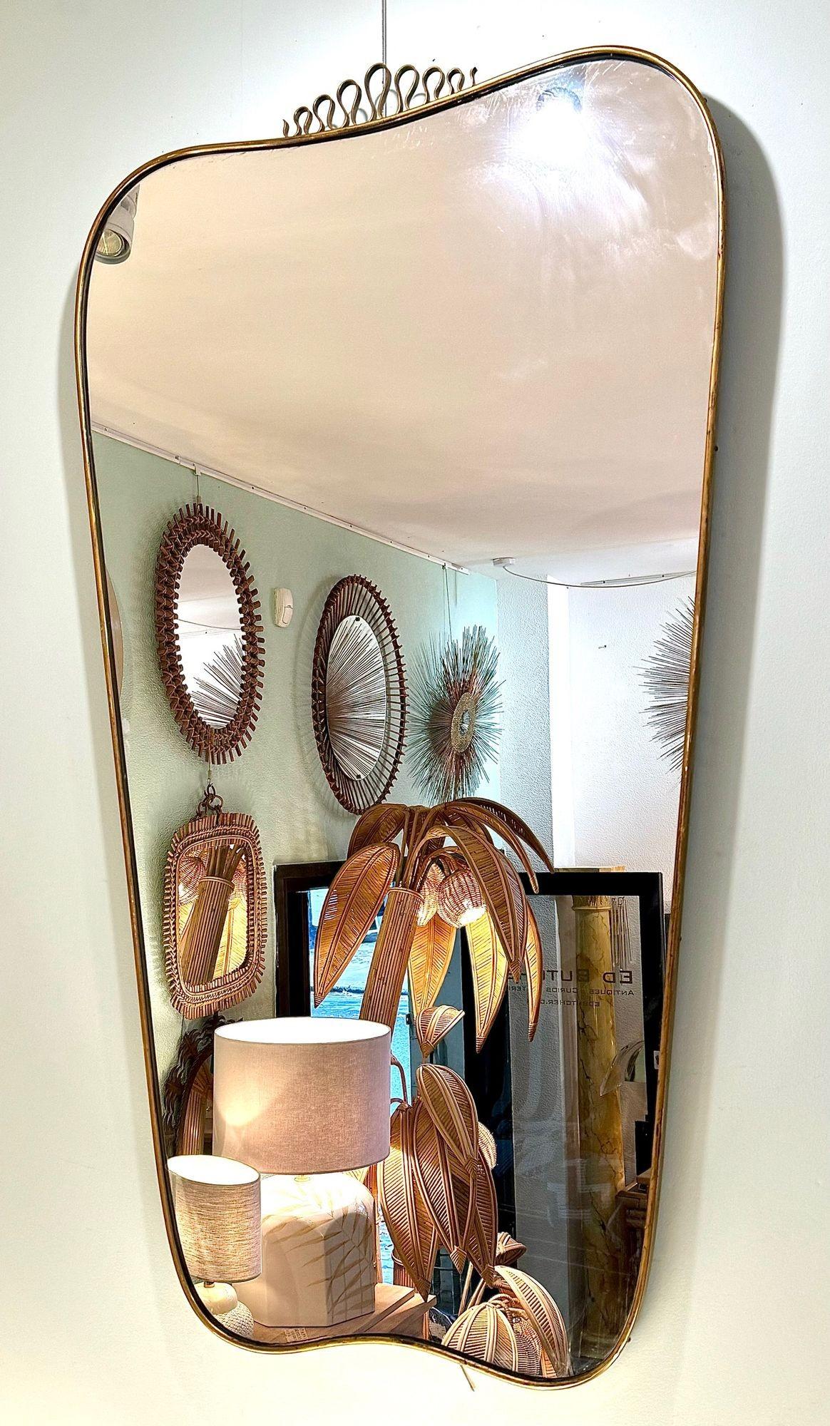Un delizioso specchio di grandi dimensioni con cornice in ottone massiccio originale degli anni '50, attribuito a Gio Ponti, con dettagli in ottone, lastra di specchio originale e schienale in legno massiccio.