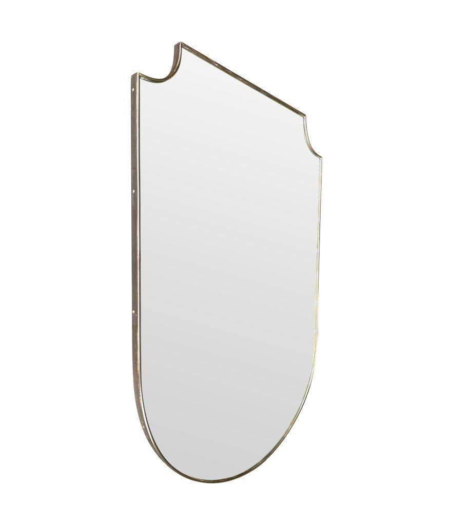 A large orignal 1950s Italian brass framed shield mirror with orignal mirror plate and solid wood back. The condition is good and there are a couple of very small foxing marks each max 2mm totally consistent with age and the frame has a dark natural