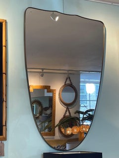 A large orignal Italian 1950s shield mirror with brass frame