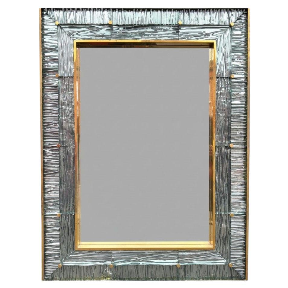 A large orignal Italian 1970s solid brass mirror with blue Murano glass frame