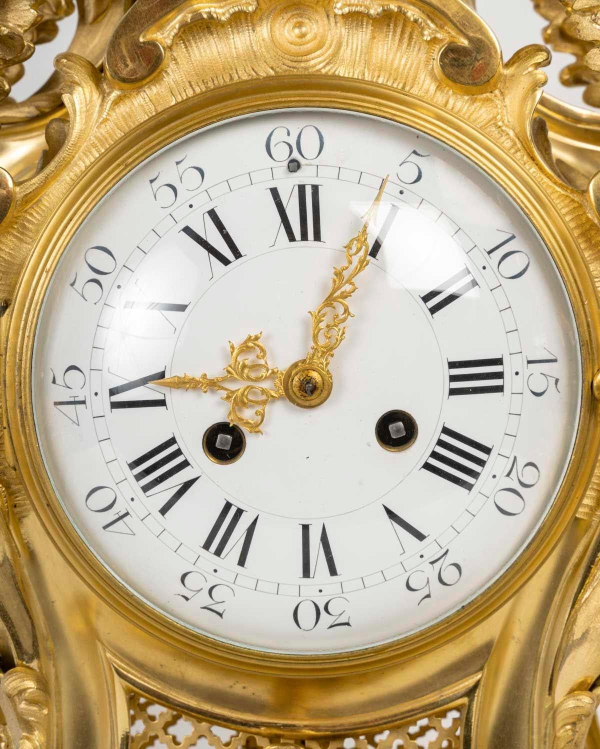 A large ormolu and chased cartel clock in the Louis XV style, 19th century.

A 19th century ormolu cartel clock in the Louis XV style, decorated with a musical cherub with a lyre.
H: 59cm, W: 41.5cm, D: 17cm