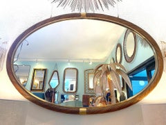 A large oval Italian 1970s Crespi style twisted rattan and brass mirror